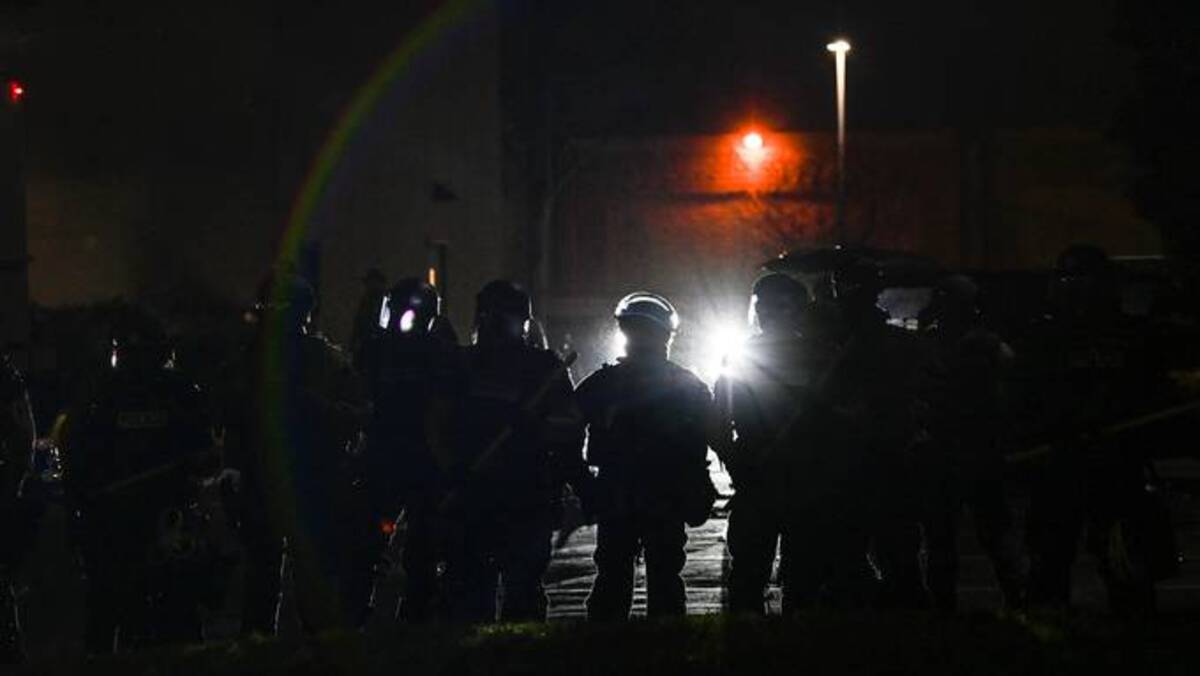 Police officers stand in position as demonstrators protest the fatal police shooting of Daunte Wright outside the Brooklyn Center Police Station on April 11 in Brooklyn Center, Minn. (Joshua Lott/The Washington Post)