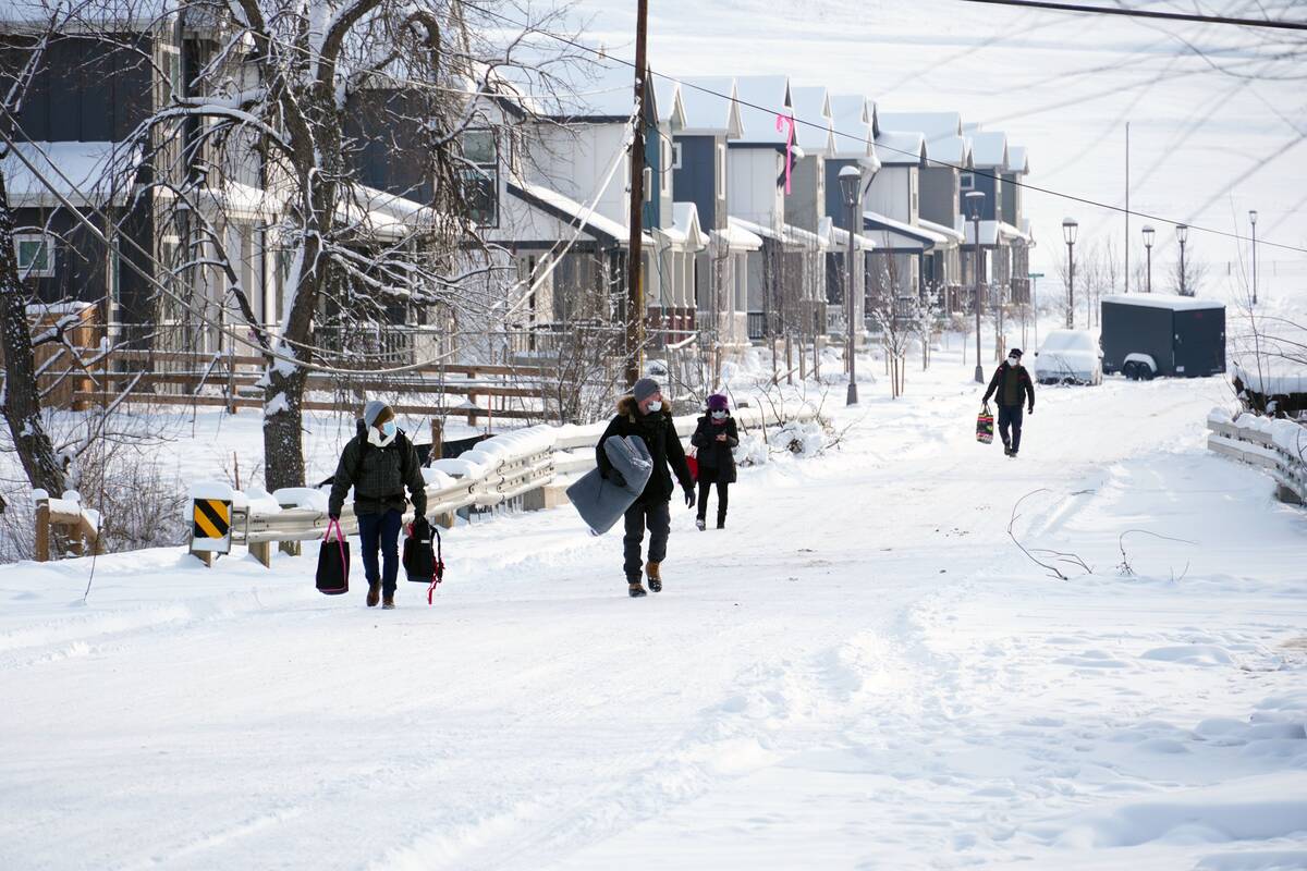 People carry their belongings in Superior, Colo., on Jan. 1. A wildfire there destroyed many homes. (Eugene Garcia/AP)