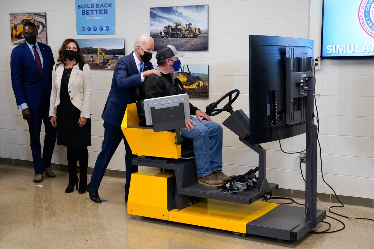 President Biden visits the International Union of Operating Engineers Local 324 training facility on Oct. 5 in Howell, Mich. Michigan Lt. Gov. Garlin Gilchrist, left, and Michigan Gov. Gretchen Whitmer observe. (Evan Vucci/AP)