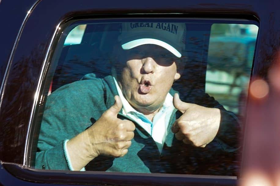 President Trump thanks supporters from his limo on Sunday as he departs a round of golf at the Trump golf course in Sterling, Va. (Steve Helber/AP)
