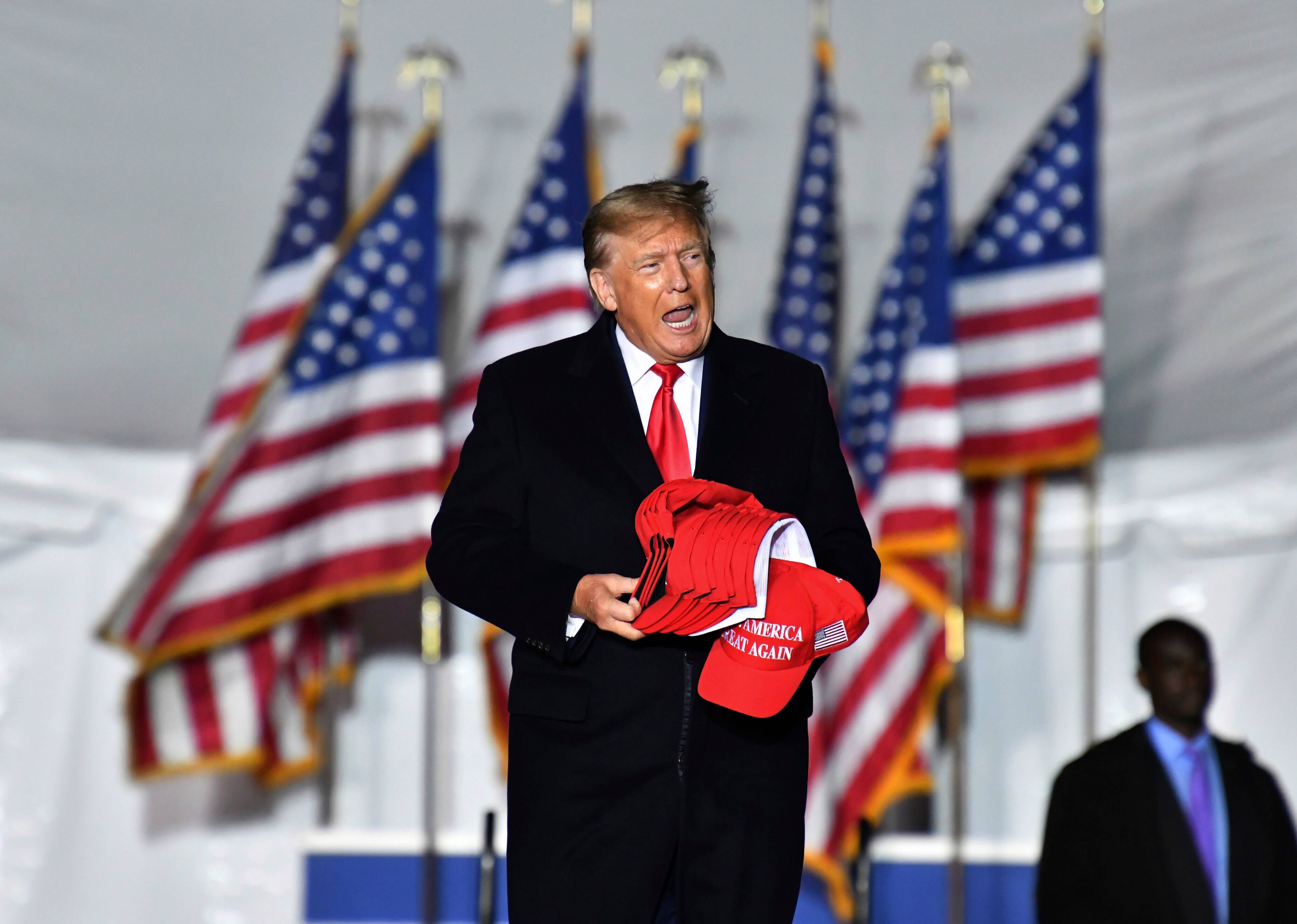 Former president Donald Trump enters the stage during a rally for Georgia GOP candidates at Banks County Dragway in Commerce, Ga., on Saturday. (Hyosub Shin/Atlanta Journal-Constitution via AP)