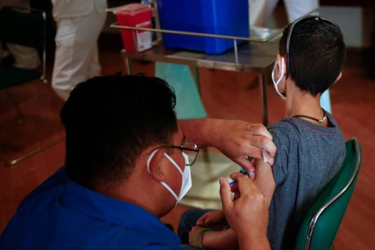 A child receives a dose of the Pfizer-BioNTech coronavirus disease vaccine during a vaccination program for minors between the ages of 12 to 17 with underlying medical conditions or disability. (Jose Luis Gonzalez/Reuters)
