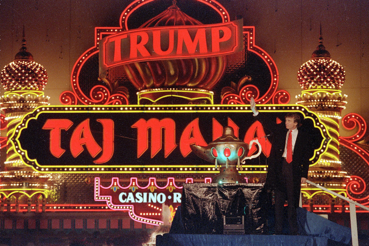 &nbsp;Trump stands next to a genie lamp at the grand opening of the&nbsp;Trump Taj Mahal Casino in Atlantic City.&nbsp;(AP/Mike Derer)</p>  