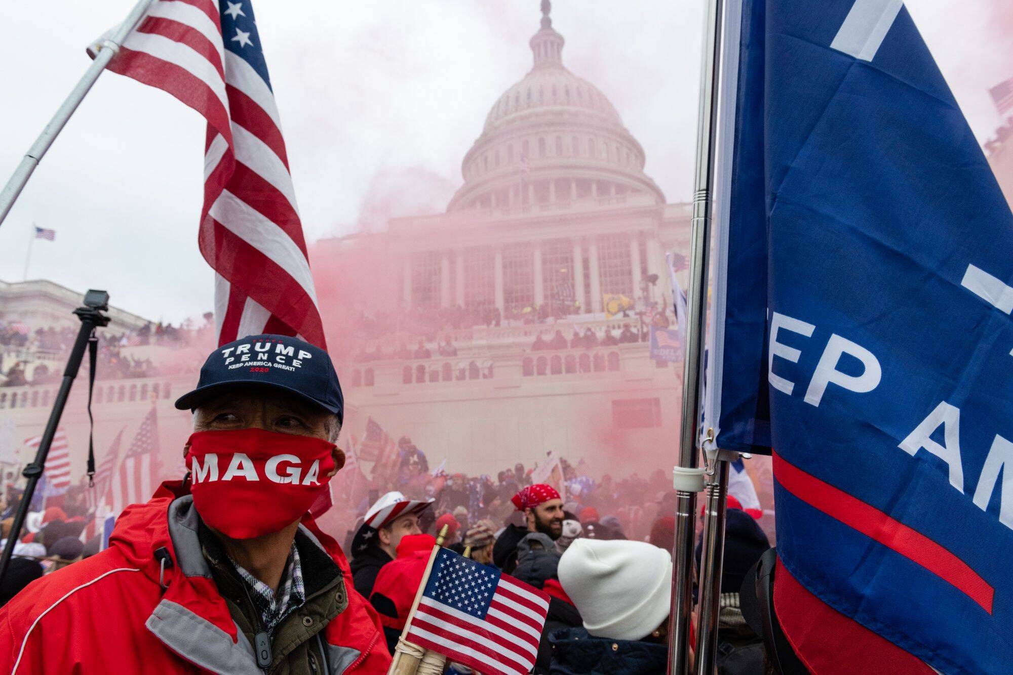 A protester unleashes a smoke grenade in front of the U.S. Capitol in Washington on Jan. 6. (Eric Lee/Bloomberg)