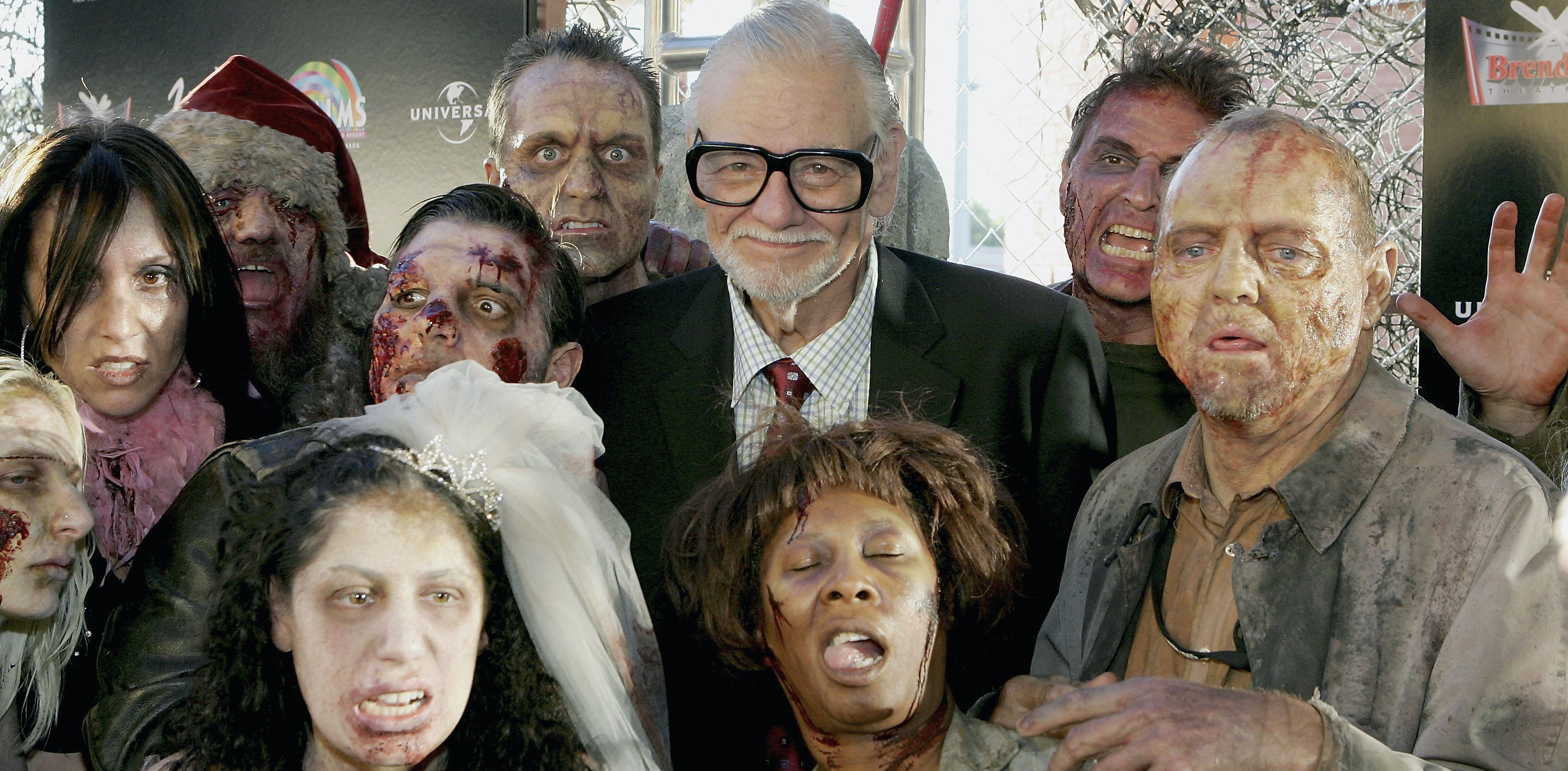 Director George A. Romero surrounded by zombies for the premiere of "Land of the Dead" in Las Vegas in 2005. (Photo by Ethan Miller/Getty Images)&nbsp;