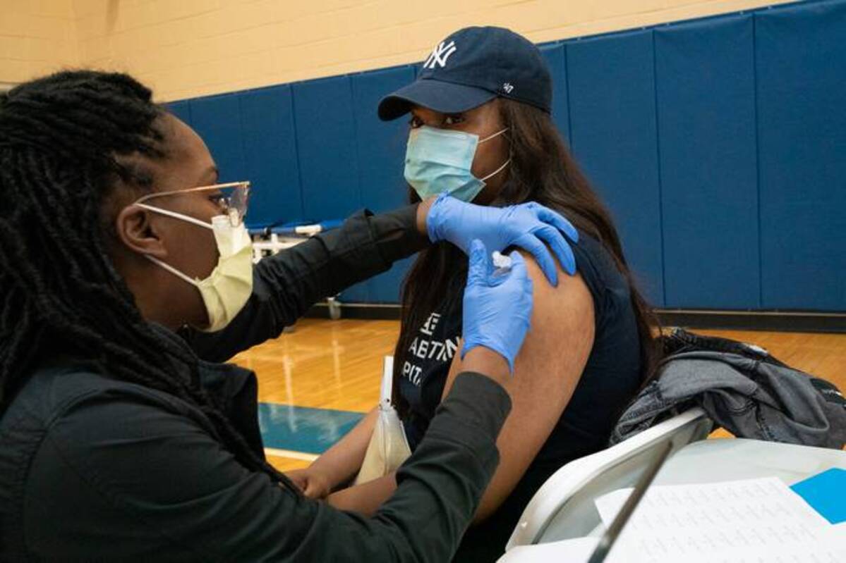 Dr. Chidinma Nwakanma gives Matteisha Young her first covid-19 shot at a vaccination clinic in Philadelphia. Dr. Nwakanma has been assisting with community clinics to encourage Black Americans to get vaccinated. (Photo by Caroline Gutman for The Washington Post)