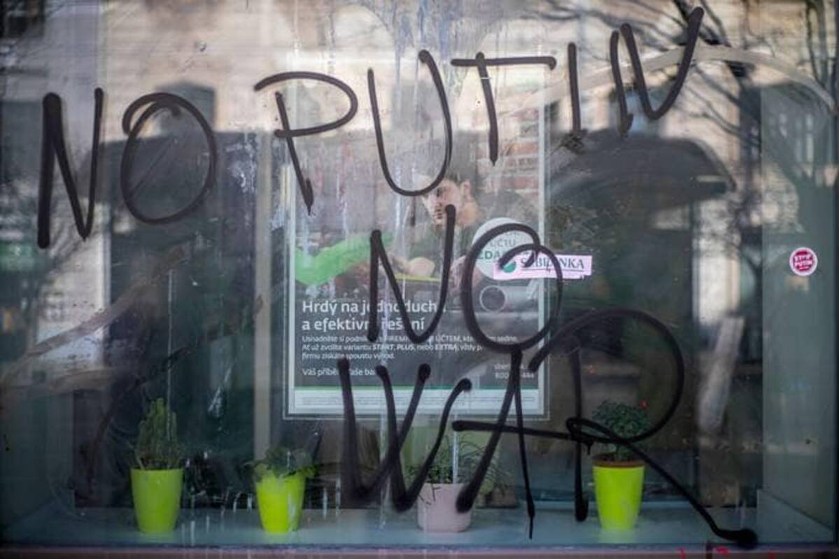 A sign 'No Putin No War' is placed at a vandalized bank branch of Sberbank Canal Zone in Prague, Czech Republic, on Wednesday. (Martin Divisek /EPA-EFE/Shutterstock)&nbsp;
