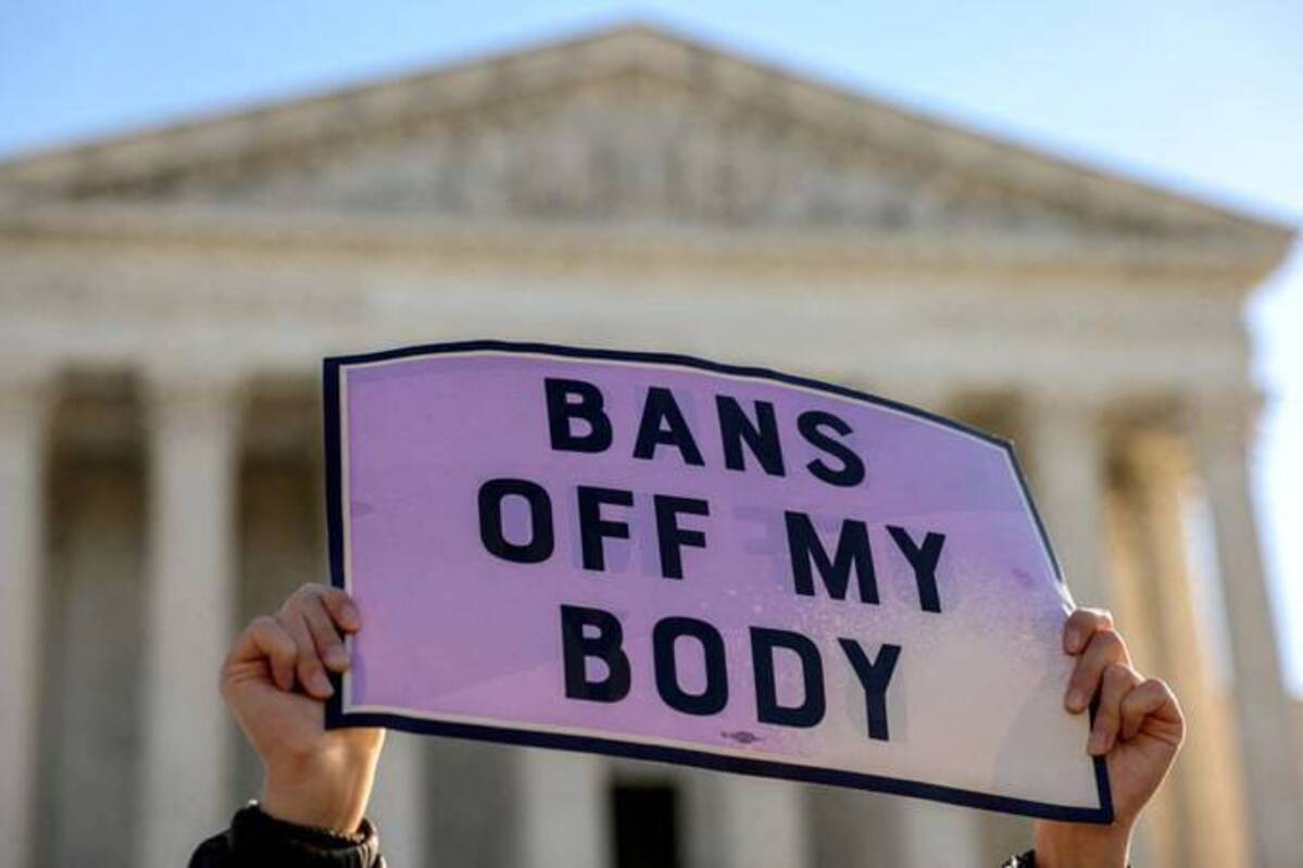 An abortion rights demonstrator holds a sign outside the Supreme Court in Nov. 2021. REUTERS/Evelyn Hockstein/File Photo