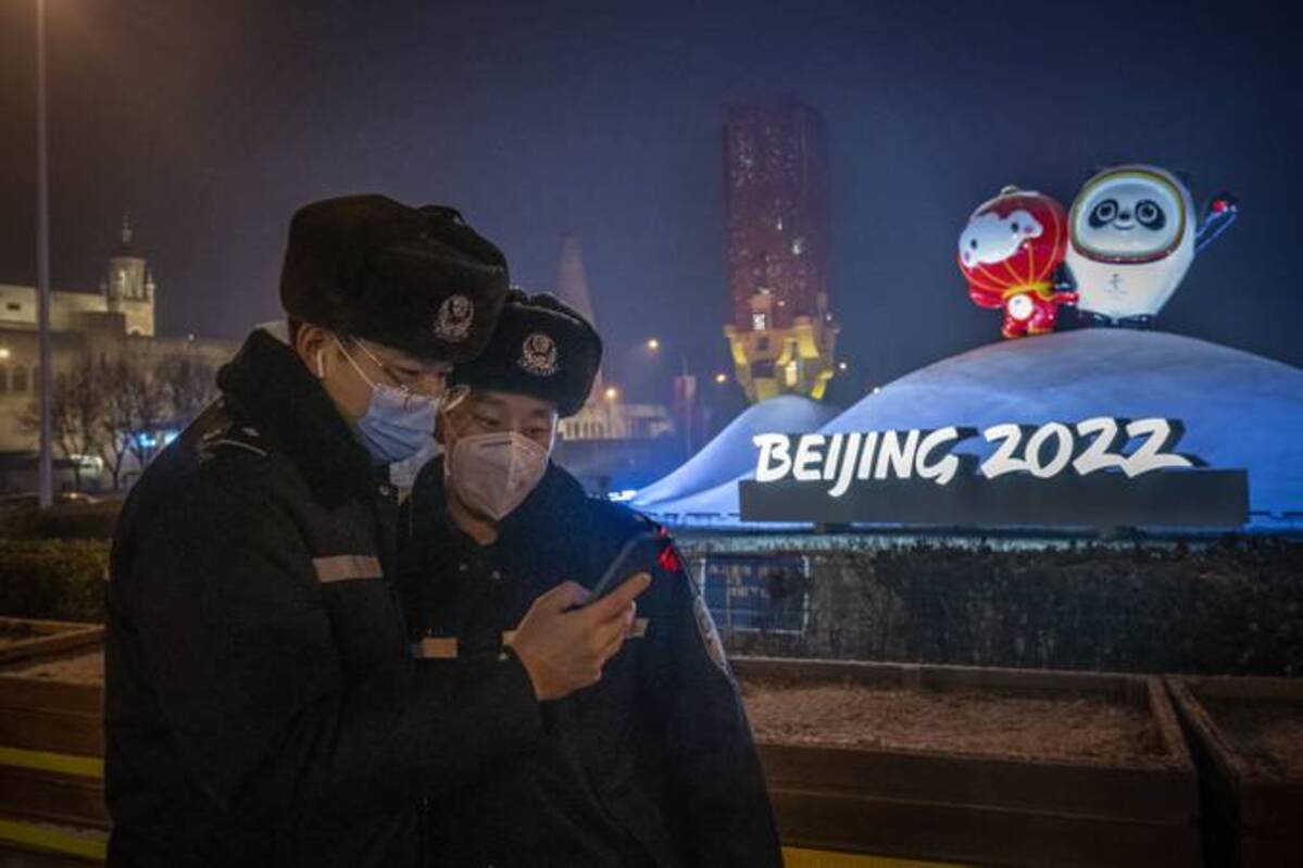 Police officers stand near a display with the Beijing 2022 Winter Olympics and Paralympics mascots. (Andrea Verdelli/Getty Images)