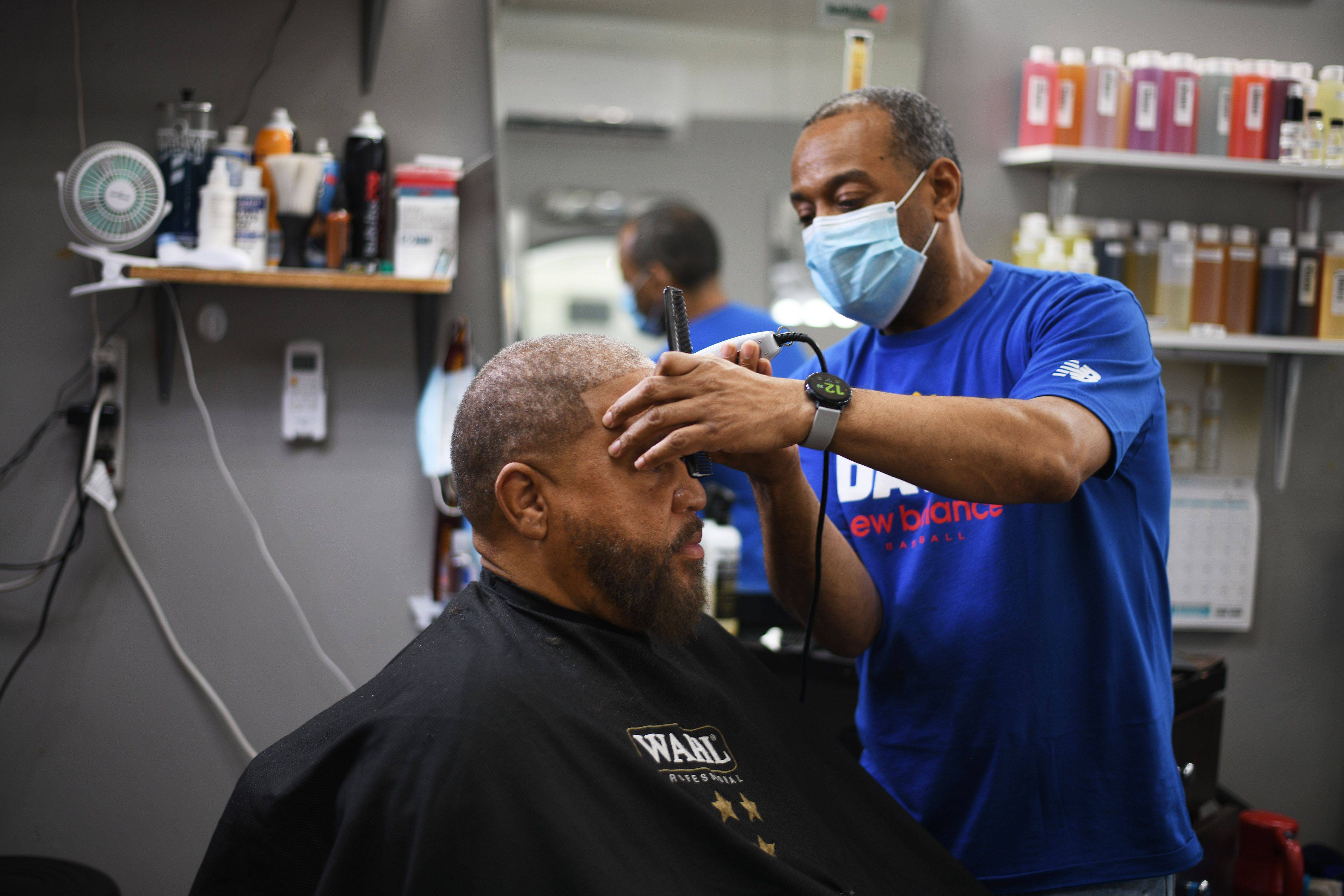 David Branch, owner of Street Cutts in Washington, cuts Wayne Monk's hair on May 22. (Astrid Riecken/The Washington Post)