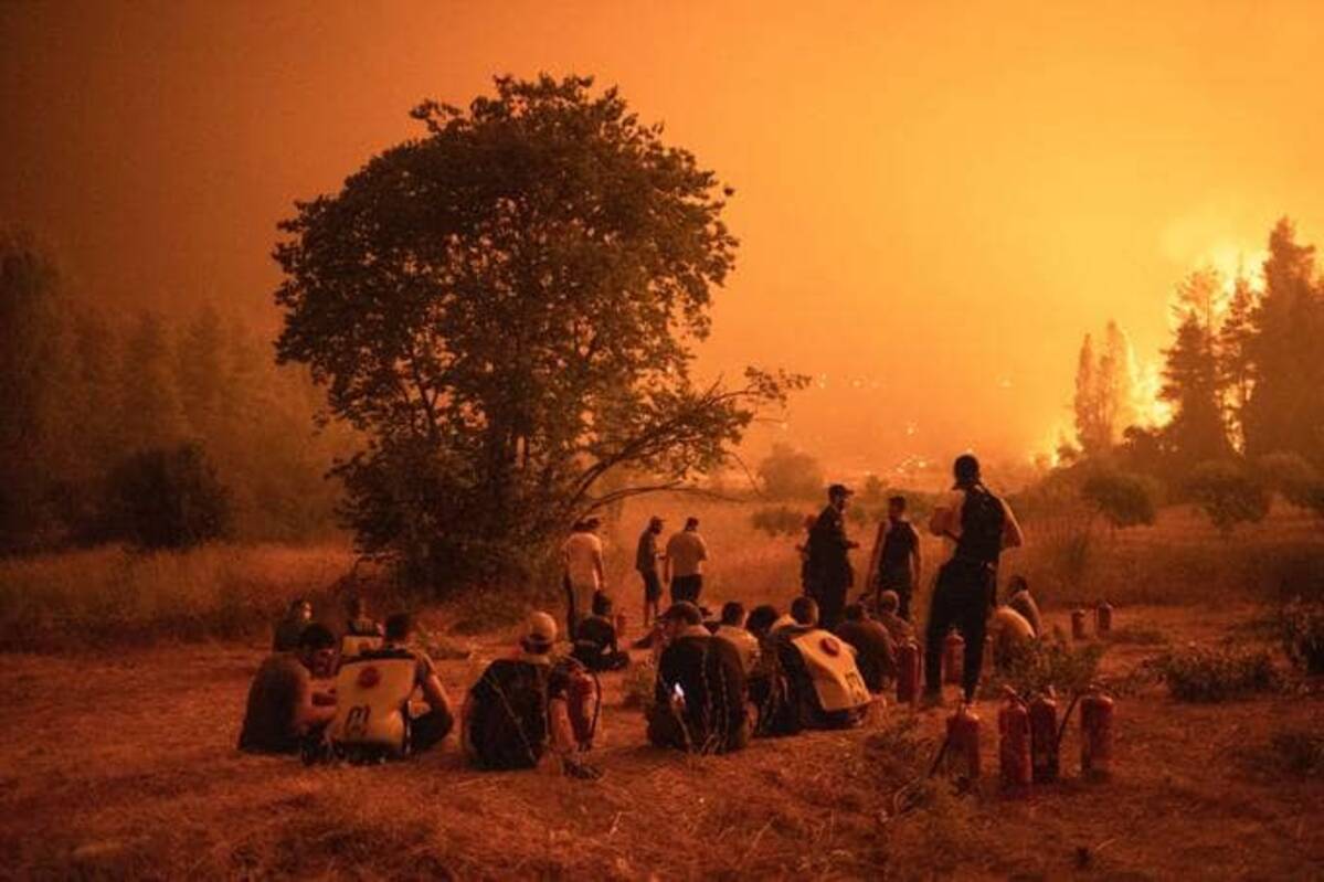 Residents watch a wildfire outside Kamatriades in Greece. (Konstantinos Tsakalidis/Bloomberg News)