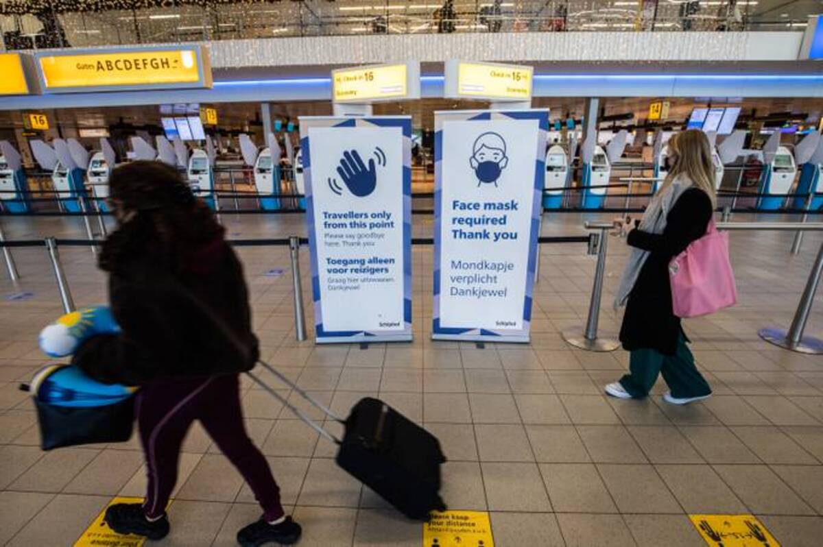 A sign indicating the requirement for protective face masks by the check-in area in the departures hall at Schiphol Airport, operated by the Royal Schiphol Group N.V. in Amsterdam. (Peter Boer/Bloomberg News)