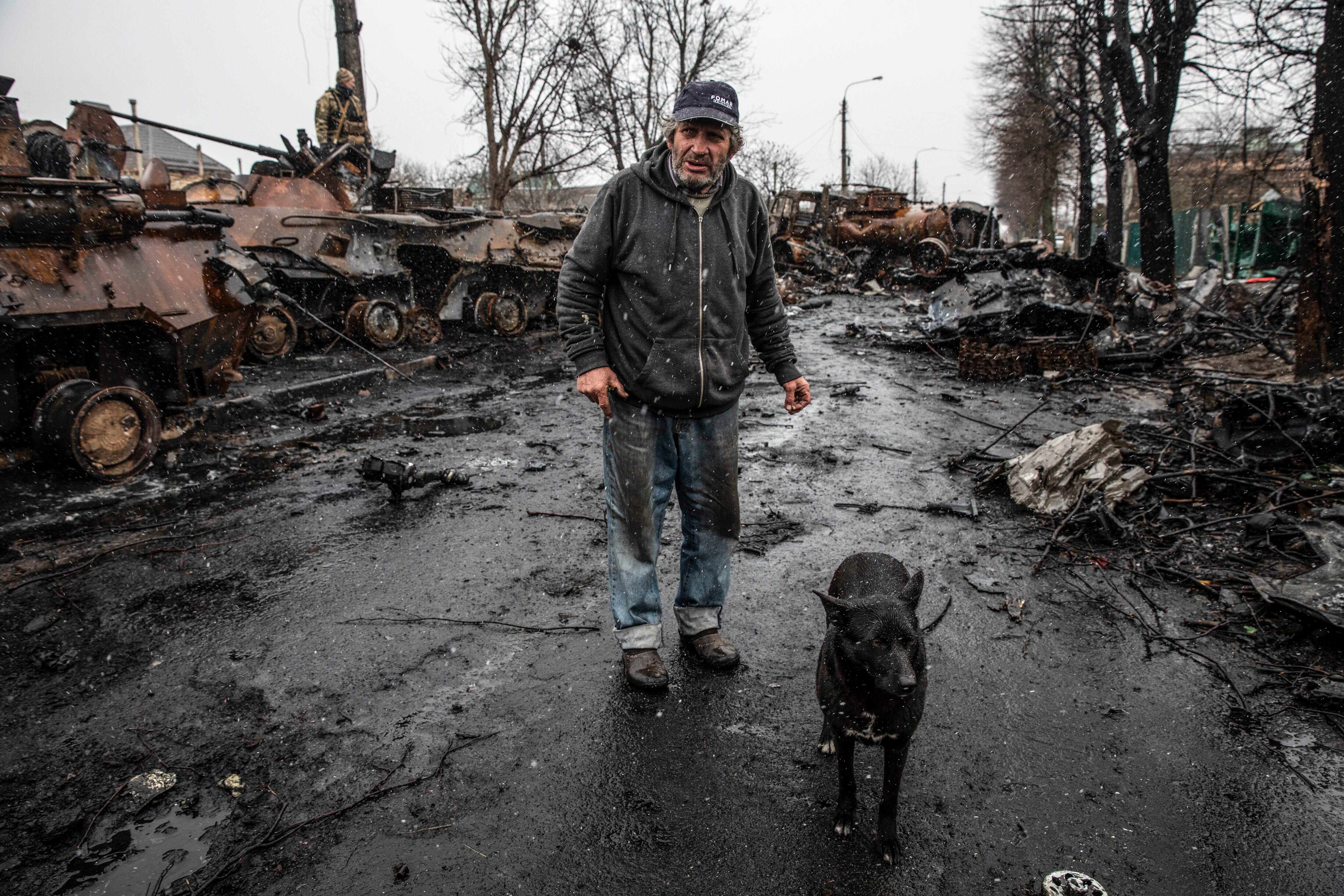 Kostya Momotov, 69, stands outside by destroyed Russian tanks, armored vehicles and other equipment litter where he lives in a residential neighborhood in Bucha, Ukraine on April 3. (Heidi Levine for The Washington Post)