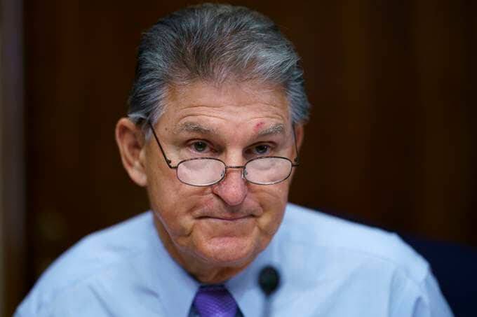 Sen. Joe Manchin III (D-W.Va) prepares to chair a hearing in the Senate Energy and Natural Resources Committee in August as lawmakers worked to advance the $1 trillion bipartisan bill. (J. Scott Applewhite/AP)