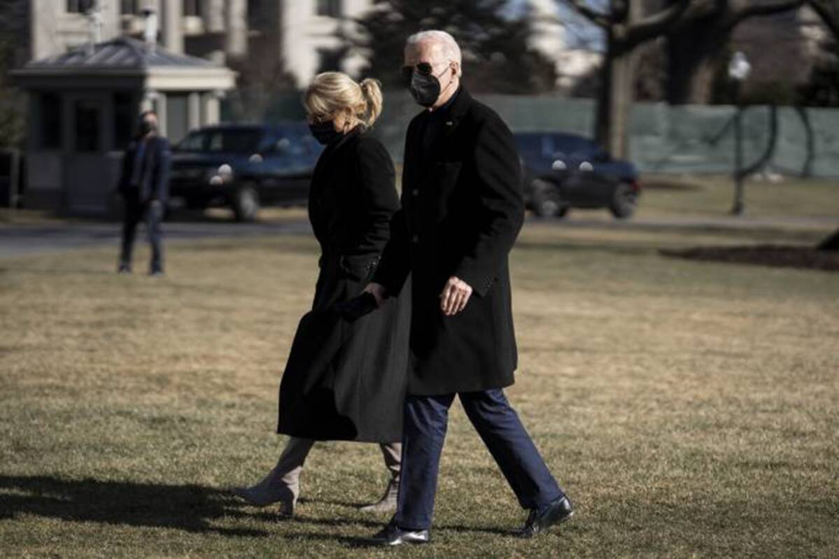 President Biden and first lady Jill Biden walk on the South Lawn of the White House after arriving on Marine One on Sunday. (Ken Cedeno/Sipa/Bloomberg)
