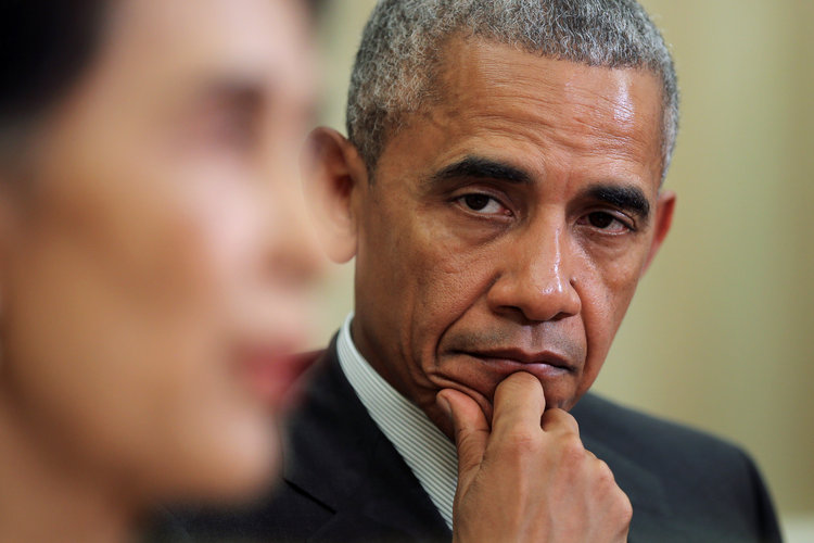 Barack Obama listens as Myanmar's Aung San Suu Kyi talks to the media during a bilateral meeting in the Oval Office. (Carlos Barria/Reuters)</p>  