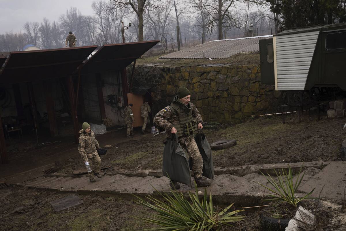 Ukrainian solders walk at an air defense base after an apparent Russian strike in Mariupol, Ukraine, &nbsp;on Feb. 24. (Evgeniy Maloletka/AP Photo)