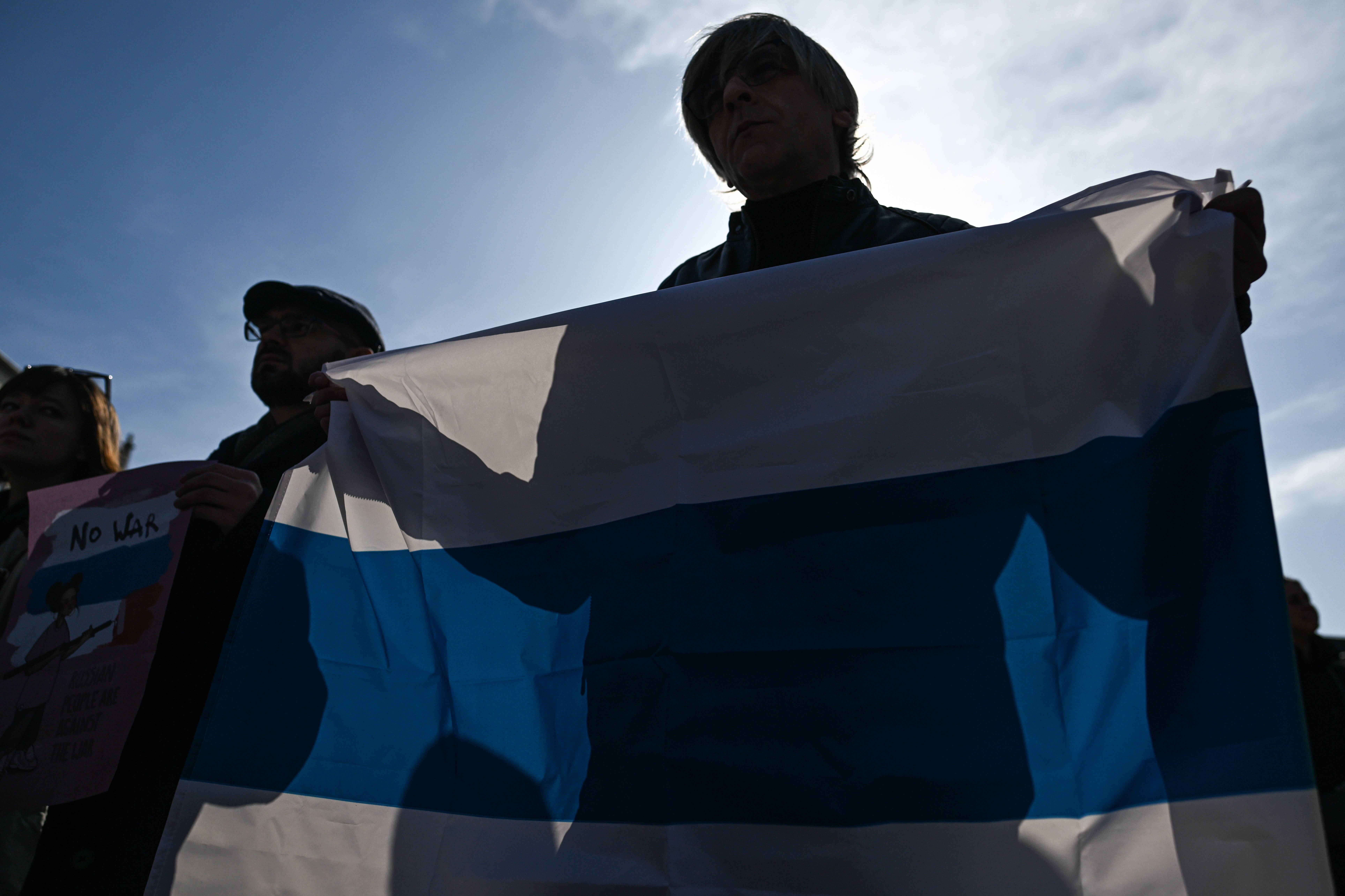 A man holds up Russia's flag (without the red strip) during a protest of the war in Ukraine in Krakow, Poland, on March 20. (Omar Marques/Getty Images)