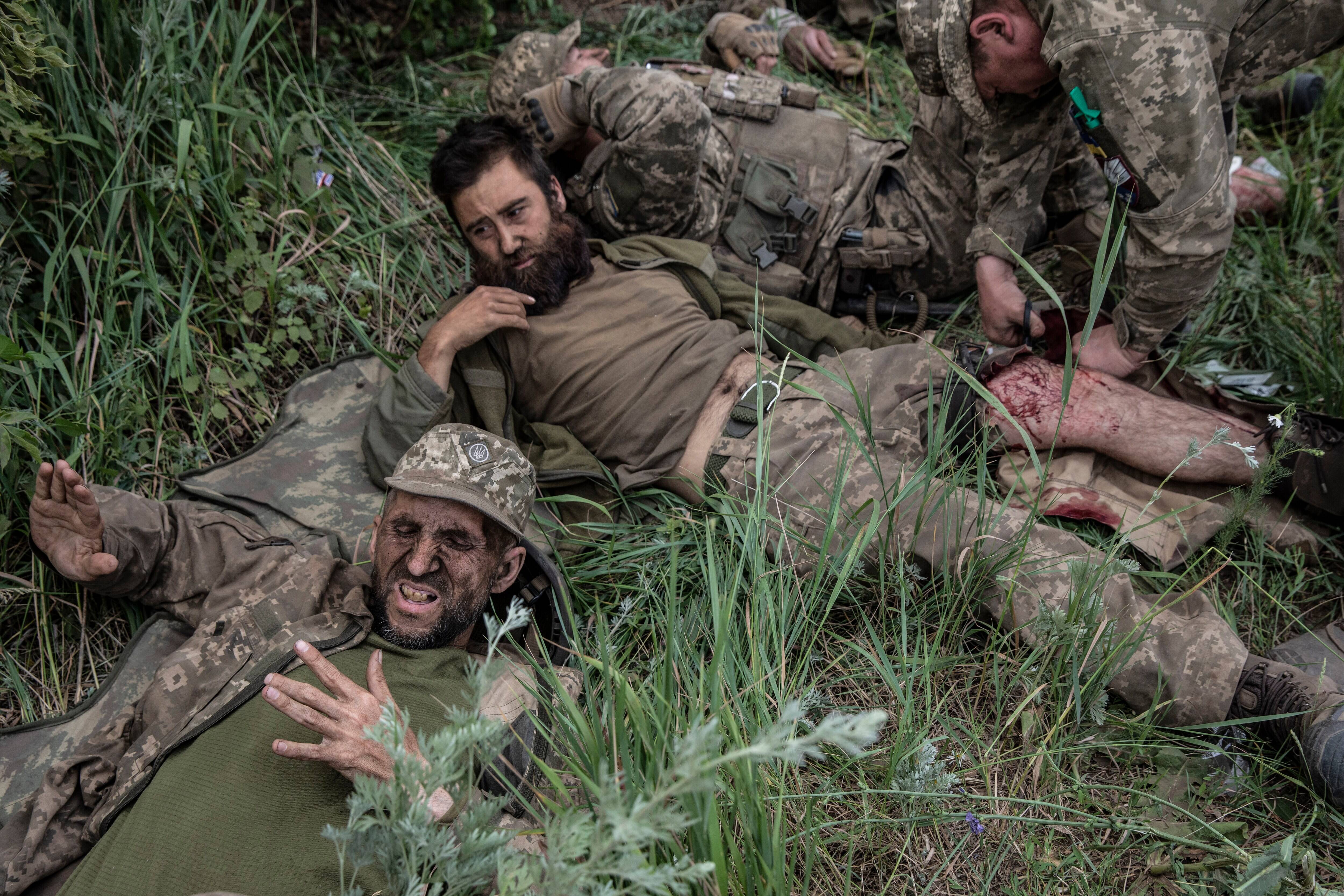 Ukrainian soldiers lie exhausted after their unit was hit by Russian cluster bombs while pulling back from the front on June 26. (Heidi Levine for The Washington Post)