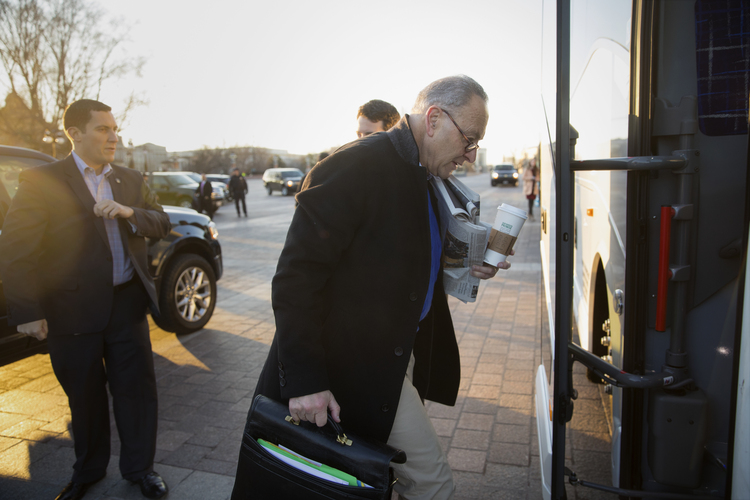 Chuck Schumer boards a bus at the Capitol to a Democratic retreat. (J. Scott Applewhite/AP)</p>
