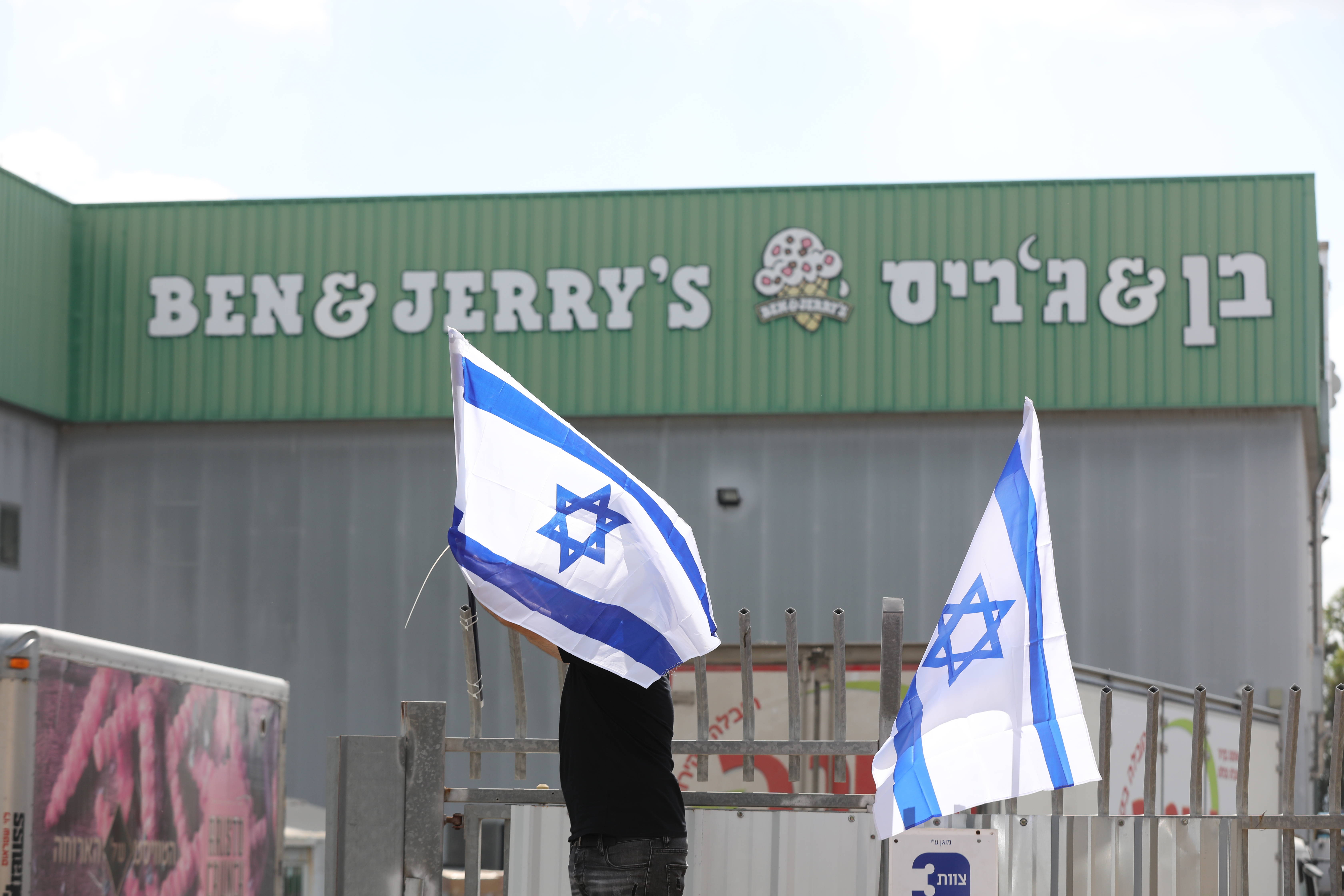 A Ben &amp; Jerry's worker sets Israeli flags in place at a factory in Be'er Tuvia, Israel, on July 22. (Abir Sultan/EPA-EFE/REX/Shutterstock)