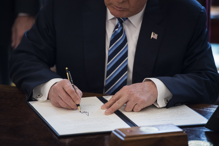 Trump signs executive orders in the Oval Office last week. (Jabin Botsford/The Washington Post)</p>  