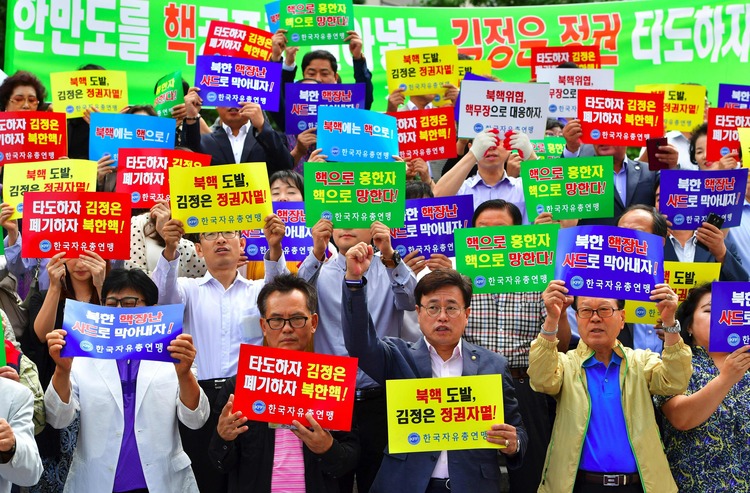 South Korean protestors hold signs&nbsp;during a protest denouncing North Korea's latest nuclear test in Seoul. (Jung Yeon-Jejung/Getty)&nbsp;</p>  