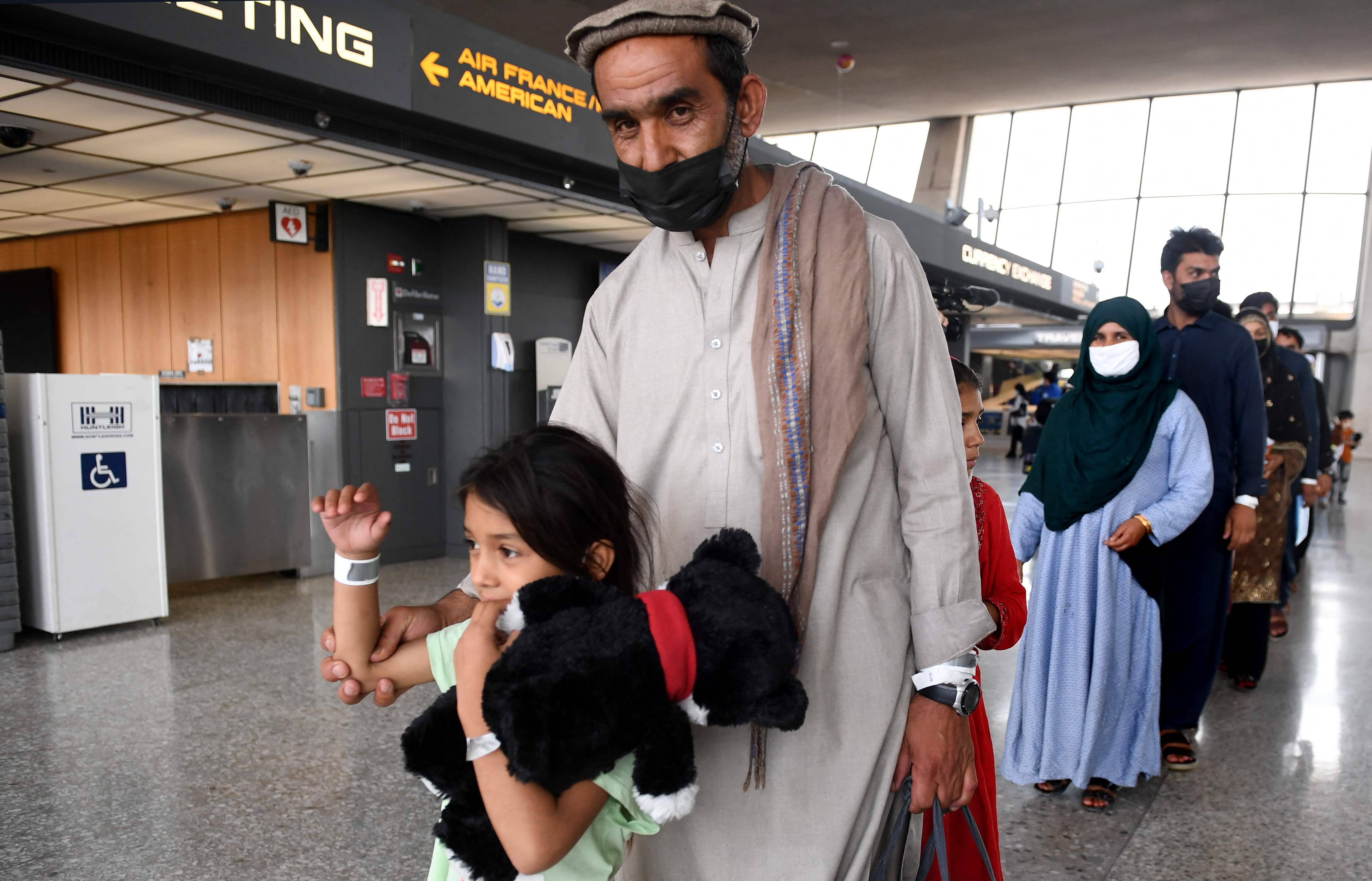 Afghan refugees arrive at Dulles International Airport outside Washington, D.C., on Friday. (Olivier Douliery/AFP via Getty Images)