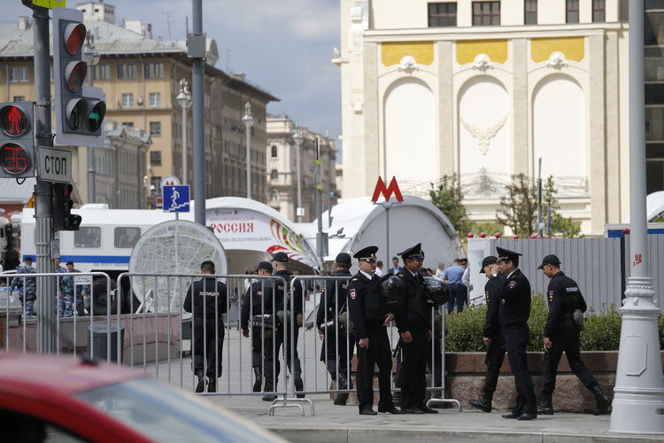 Russian police officers stand behind barricades in downtown Moscow on Monday. (Alexander Zemlianichenko/AP)</p>  
