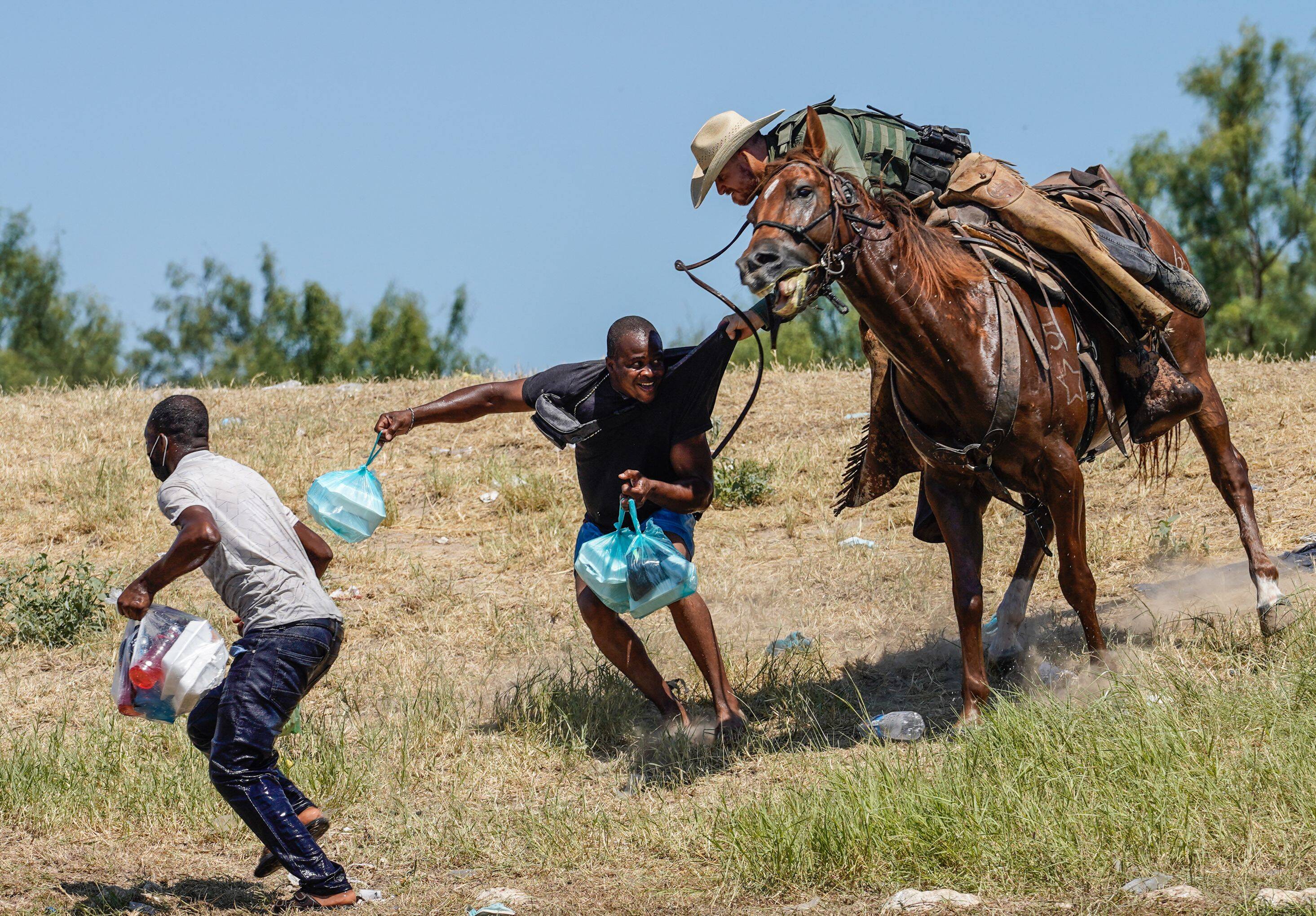 A U.S. Border Patrol agent on horseback tries to stop a Haitian migrant from entering an encampment on the banks of the Rio Grande on Sunday. (Paul Ratje/AFP via Getty Images)