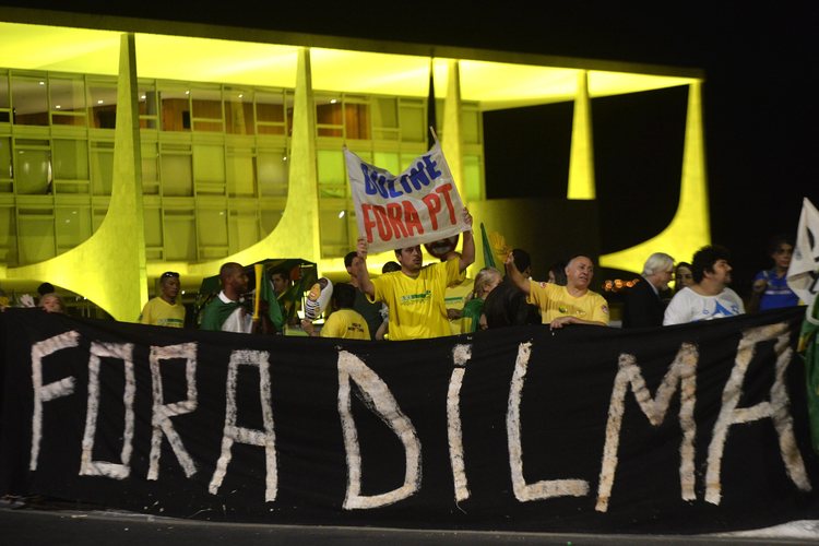 Demonstrators hold a banner last night that reads "Dilma Out"&nbsp;in Portuguese outside of Planalto Palace.&nbsp;(EPA)</p>  