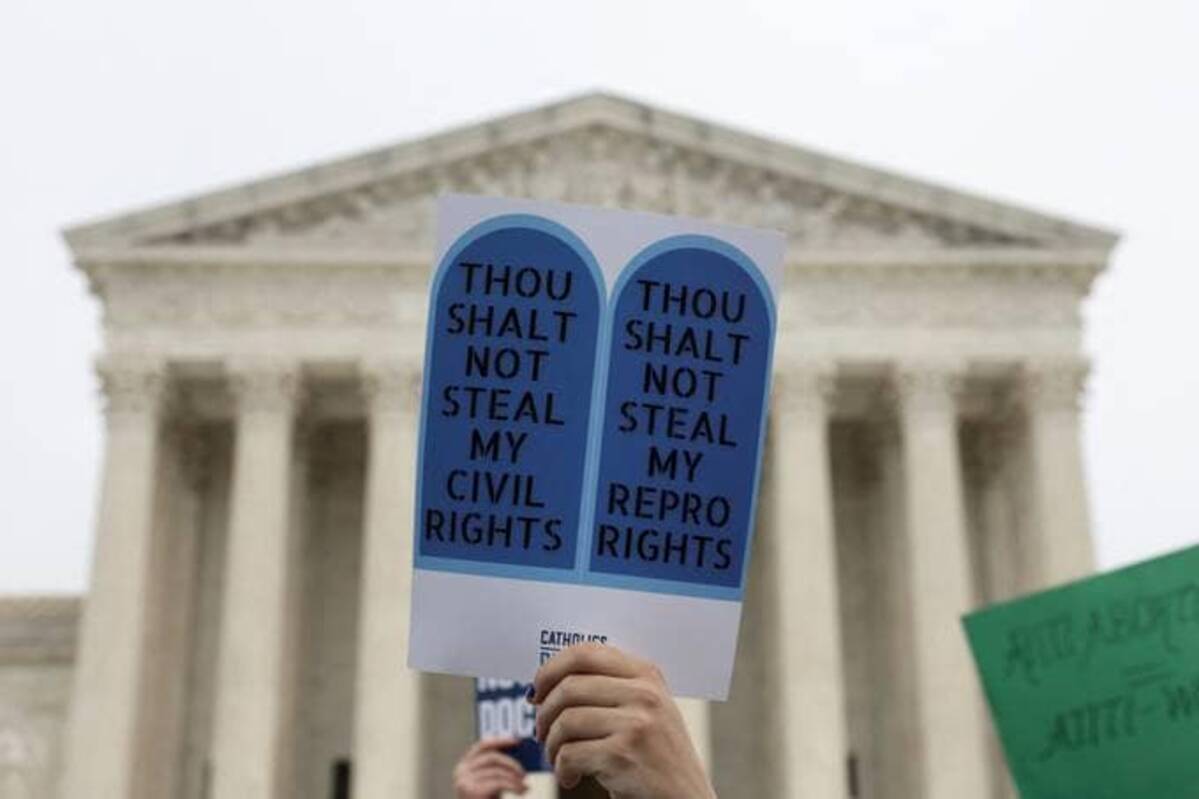 A demonstrator holds a sign during a protest outside the U.S. Supreme Court on Tuesday. (Evelyn Hockstein/Reuters)