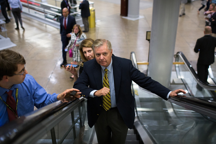 Lindsey Graham speaks with reporters on his way to a vote at the Capitol.&nbsp;(Photo by Drew Angerer/Getty Images)</p>  