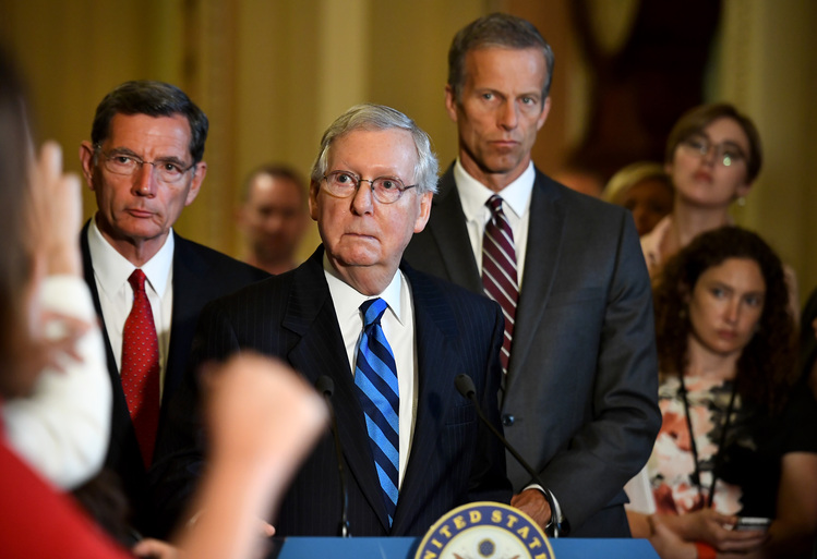Mitch McConnell, flanked by John Barrasso and John Thune, listens to a question about health care on Tuesday. (Katherine Frey/The Washington Post)  