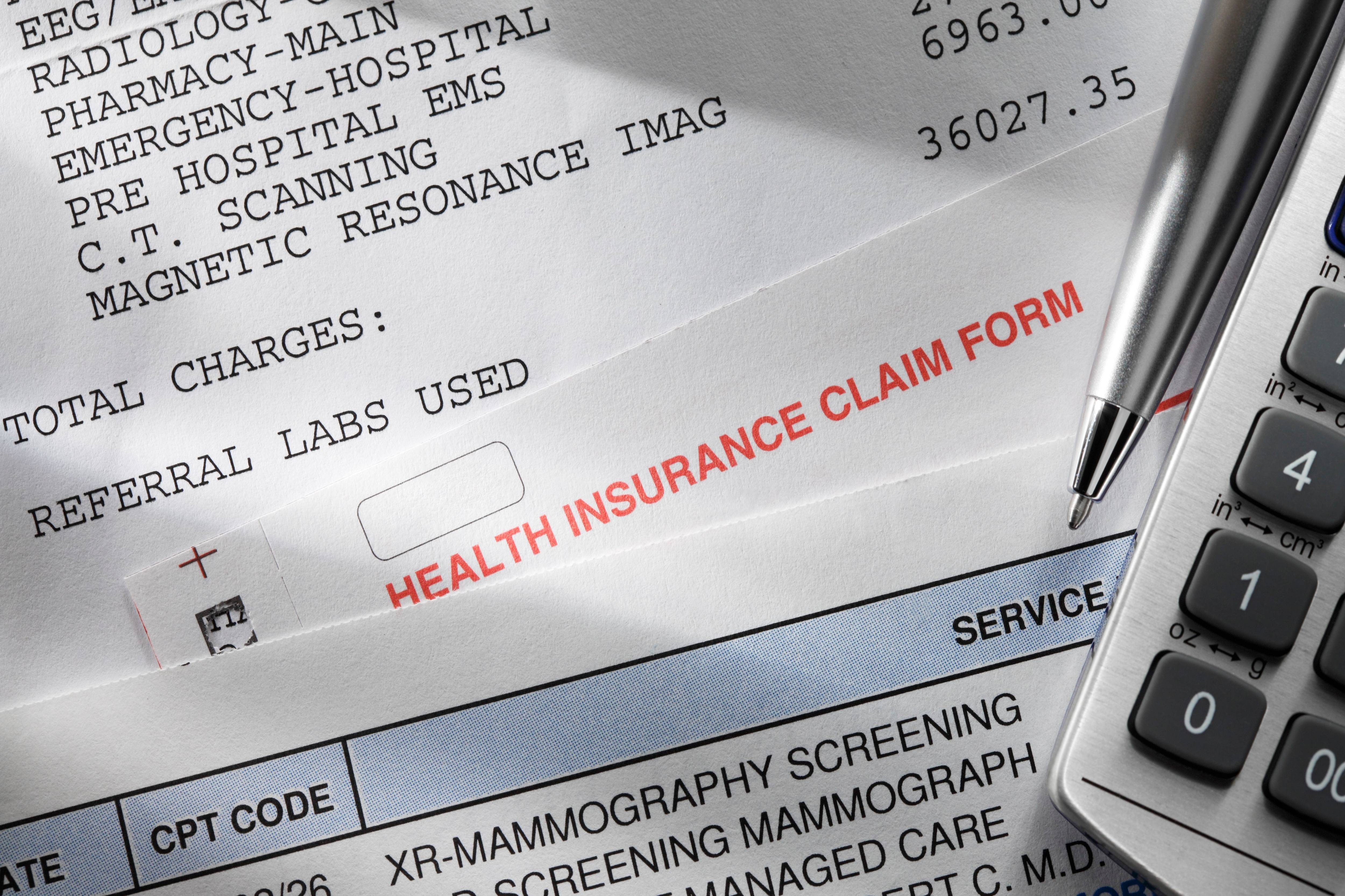 A health insurance claim form and medical bills. (iStock)