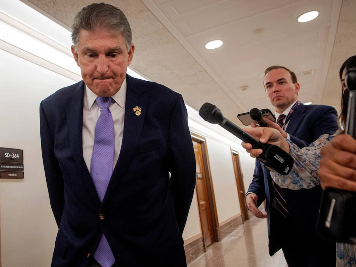 Reporters flank Democratic Sen. Joe Manchin III of West Virginia as he arrives at a July 21 hearing of the Senate Energy and Natural Resources Committee on Capitol Hill. (Bill O' Leary/The Washington Post)