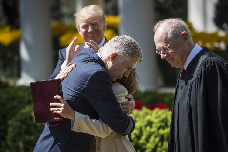 Trump watches as Neil Gorsuch hugs his wife after Anthony Kennedy administered the judicial oath during a swearing-in ceremony in the Rose Garden on April 10. (Jabin Botsford/The Washington Post)</p>  