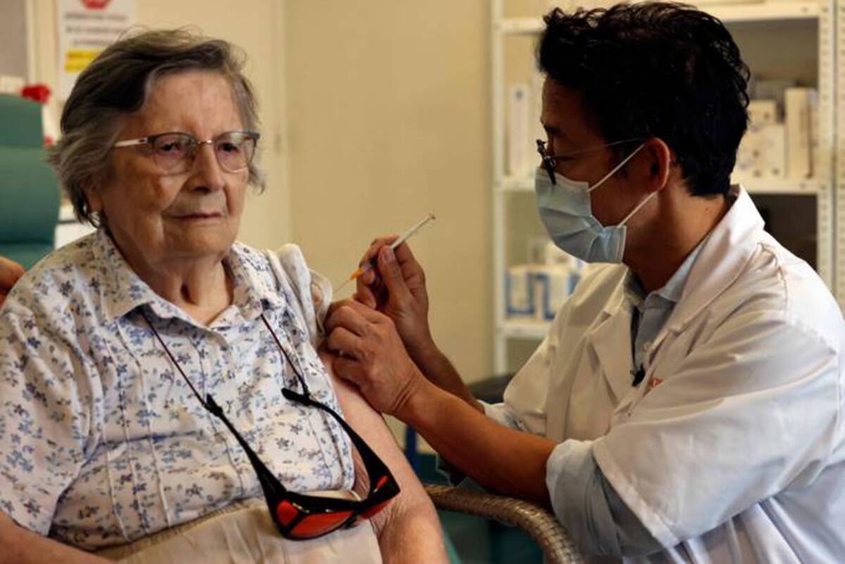 An elderly patient receives the third dose of the Pfizer-BioNTech coronavirus vaccine in Paris. (Thomas Coex/AFP)