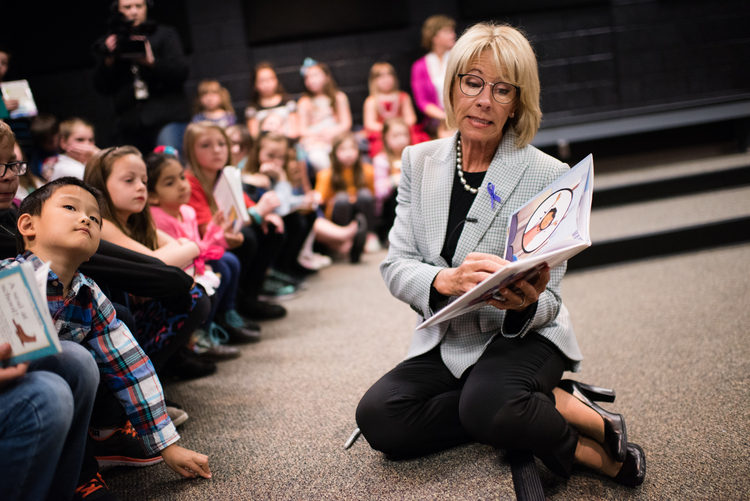 Betsy DeVos reads a story about military mothers to a group of students. (Sarah L. Voisin/The Washington Post)</p>  