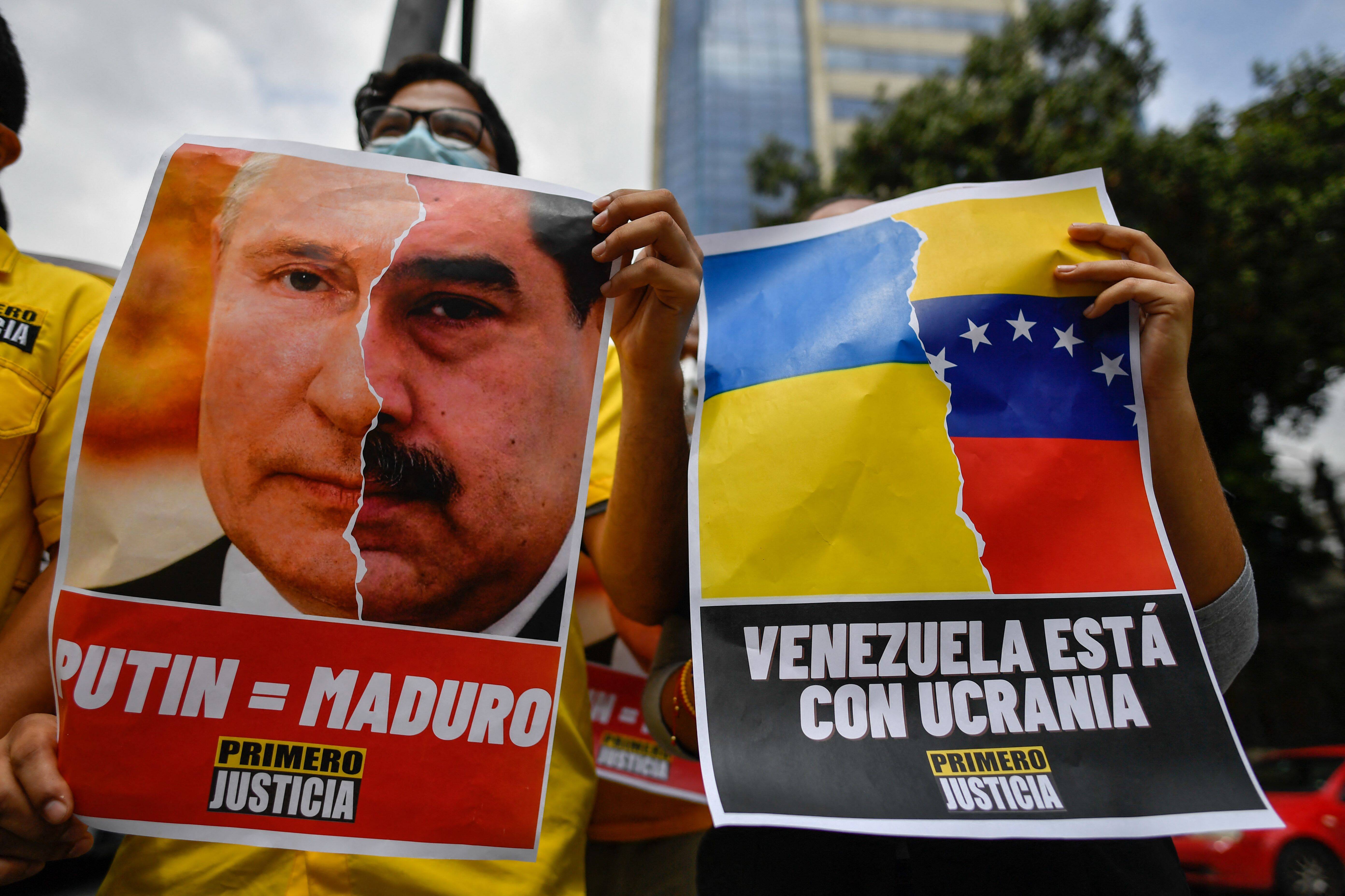 An activist member of opposition party Justice First holds a placard showing the face of Russian President Vladimir Putin and Venezuelan President Nicolás Maduro during a protest against the Russian invasion in Ukraine, in Caracas, Venezuela, on March 4. (Federico Parra/AFP/Getty Images)
