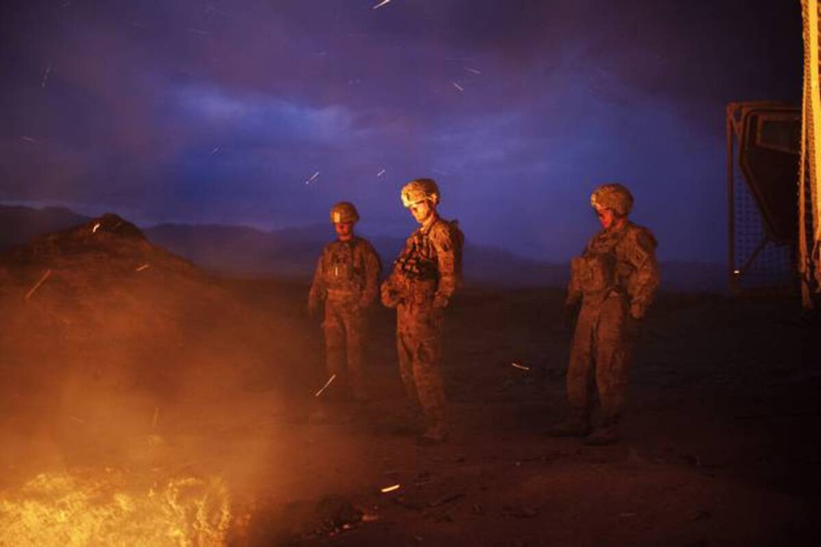 Soldiers burn trash from the Jaghatu Combat Outpost in a pit just outside the walls of the base in Afghanistan. (Lorenzo Tugnoli for The Washington Post)