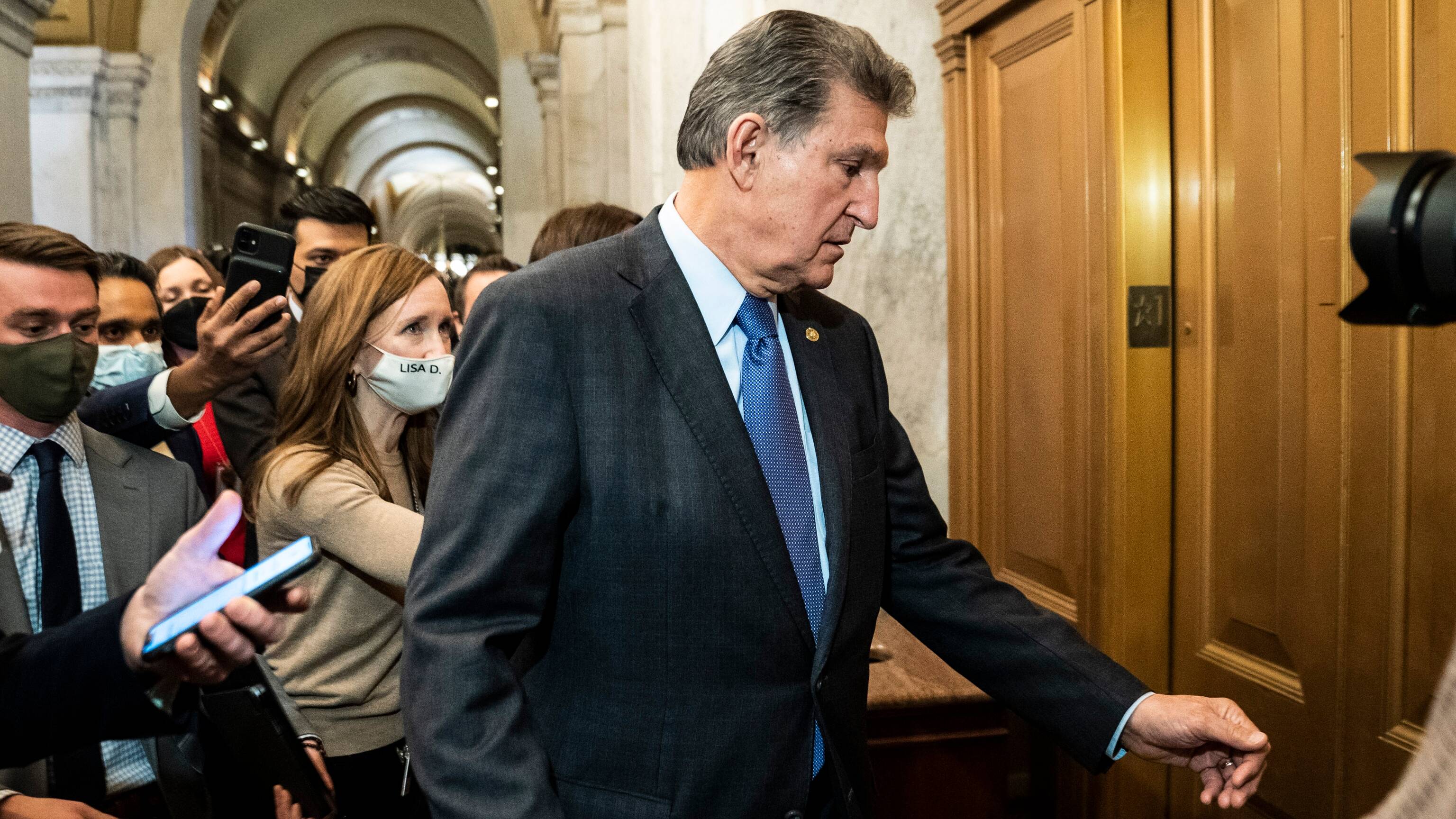 Reporters chase Sen. Joe Manchin III (D-W. Va.). (Jabin Botsford/The Washington Post)