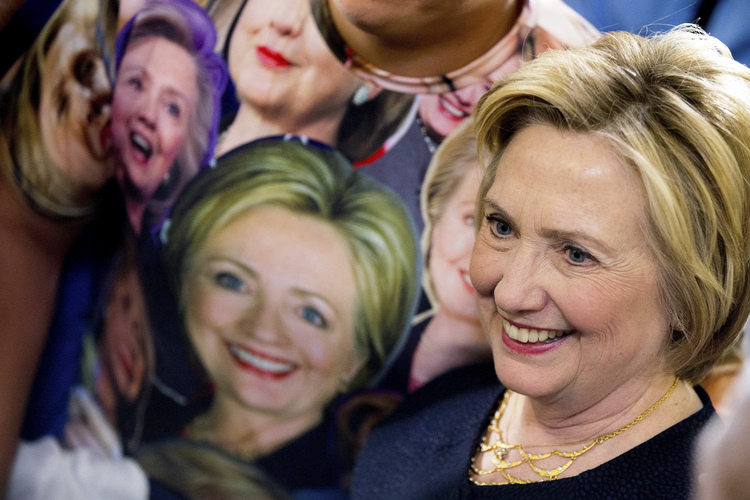 &nbsp;Clinton poses with a fan -- donned in photos of her face -- after an Ohio campaign event.&nbsp;(AP /Andrew Harnik)</p>  