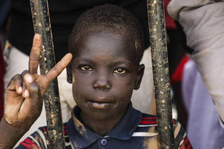 A Sudanese boy flashes a victory sign during a protest on July 18 to condemn the deadly crackdown last month in Khartoum. (Mahmoud Hjaj/AP)  