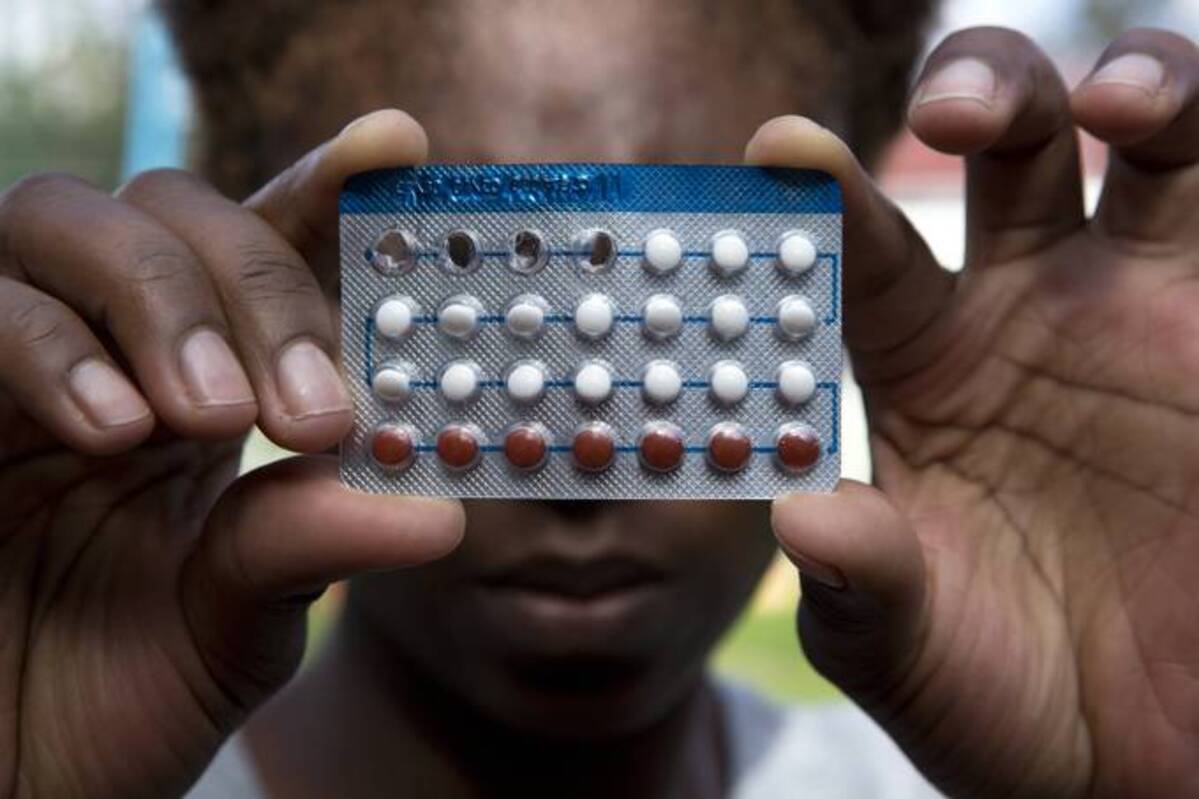 A woman holds a packet of contraceptive pills. (Tsvangirayi Mukwazhi/AP)