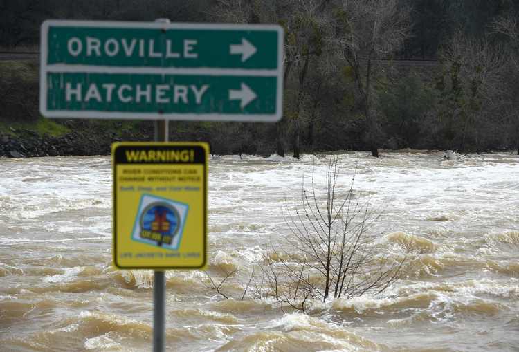 A sign is seen submerged by flowing water near Oroville, California, yesterday. Almost 200,000 people are under evacuation orders in northern California after a threat of catastrophic failure at the United States' tallest dam. The dam is 75 miles north of San Francisco. (Josh Edelson/AFP/Getty Images)</p>