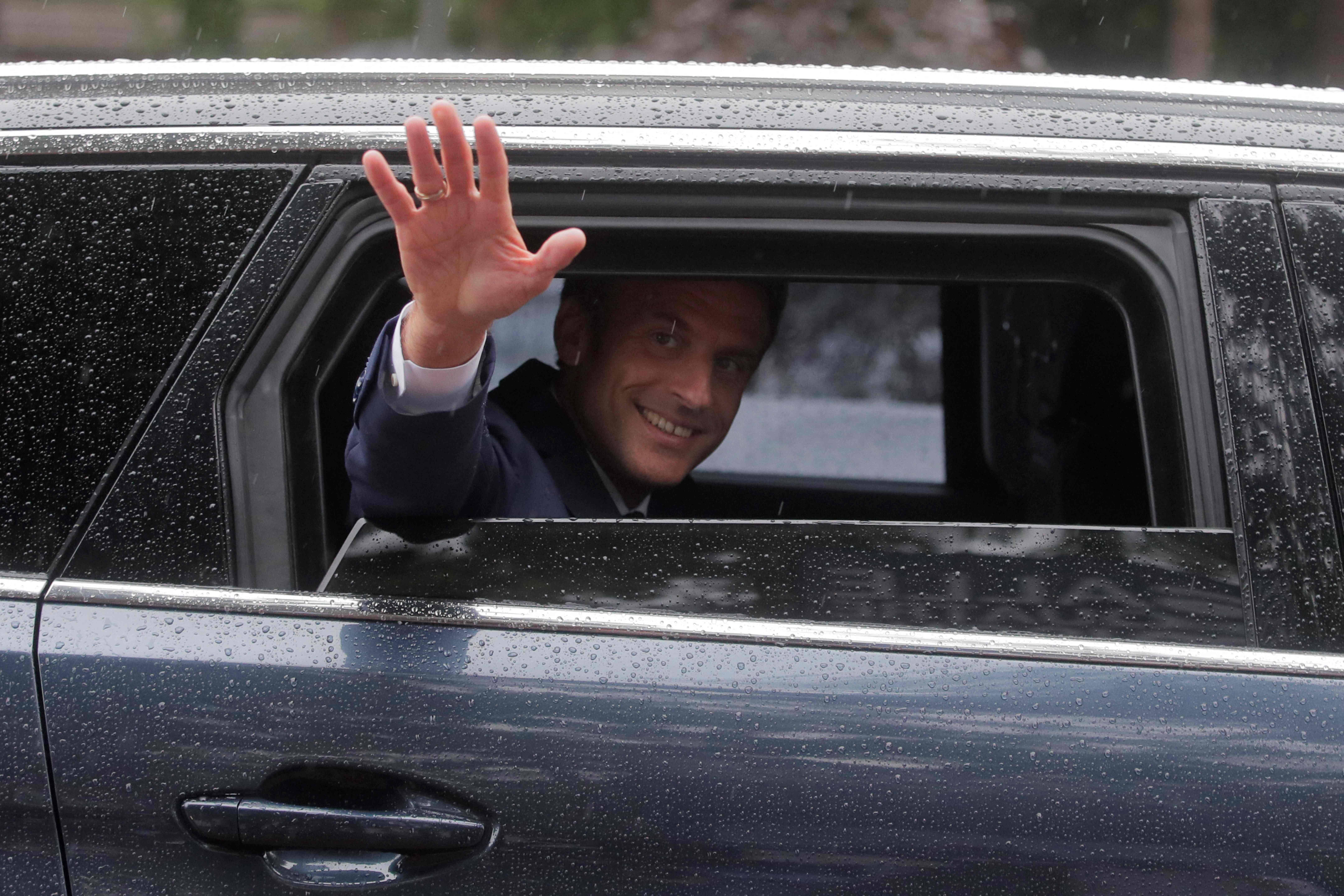 French President Emmanuel Macron waves from his car as he leaves after voting in the second stage of French parliamentary elections at a polling station in Le Touquet, northern France on June 19. (Michel Spingler/AFP/Getty Images)
