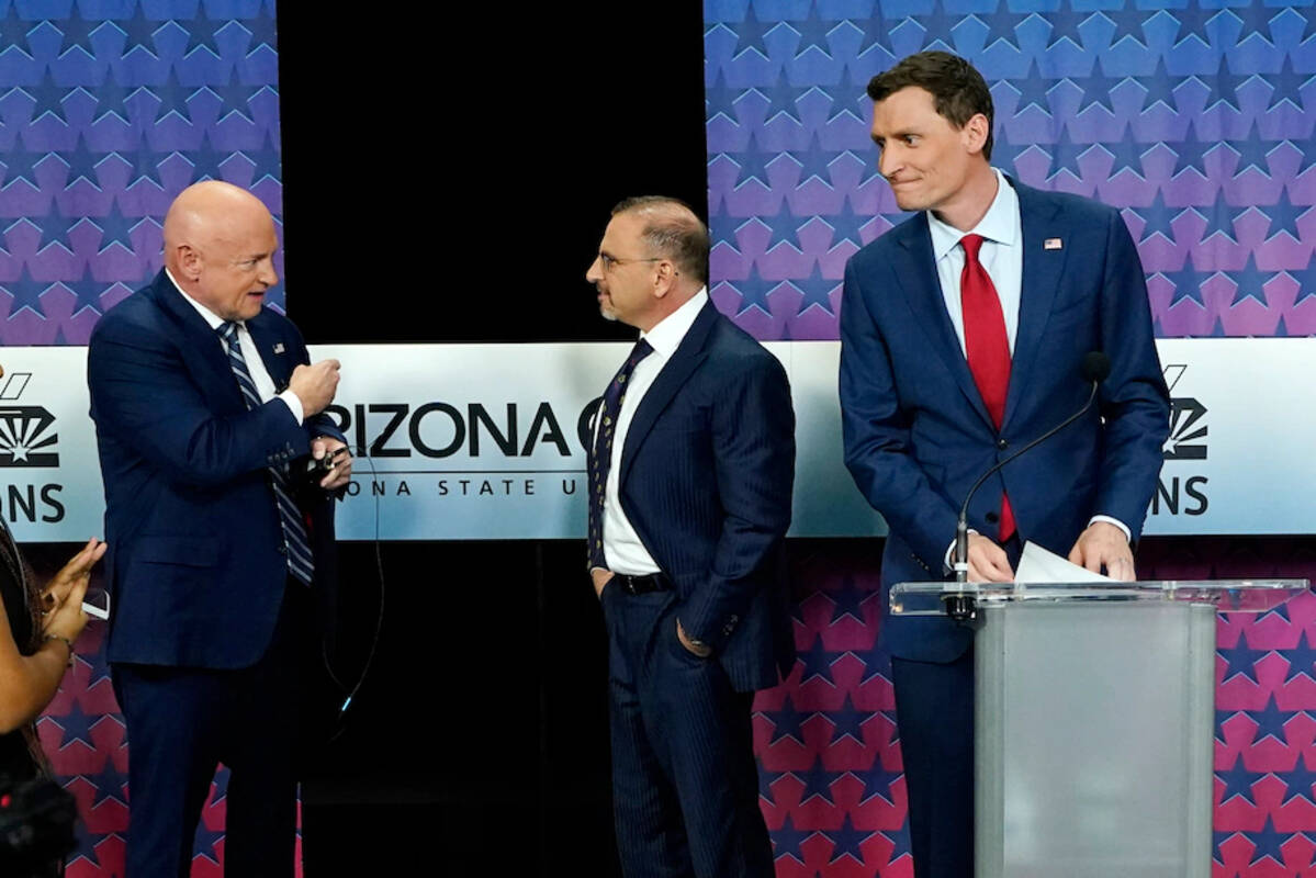Arizona Democratic Sen. Mark Kelly, left, talks with Libertarian candidate Marc Victor, middle, and Republican candidate Blake Masters before a televised debate in Phoenix on Oct. 6. (Ross D. Franklin/AP)&nbsp;