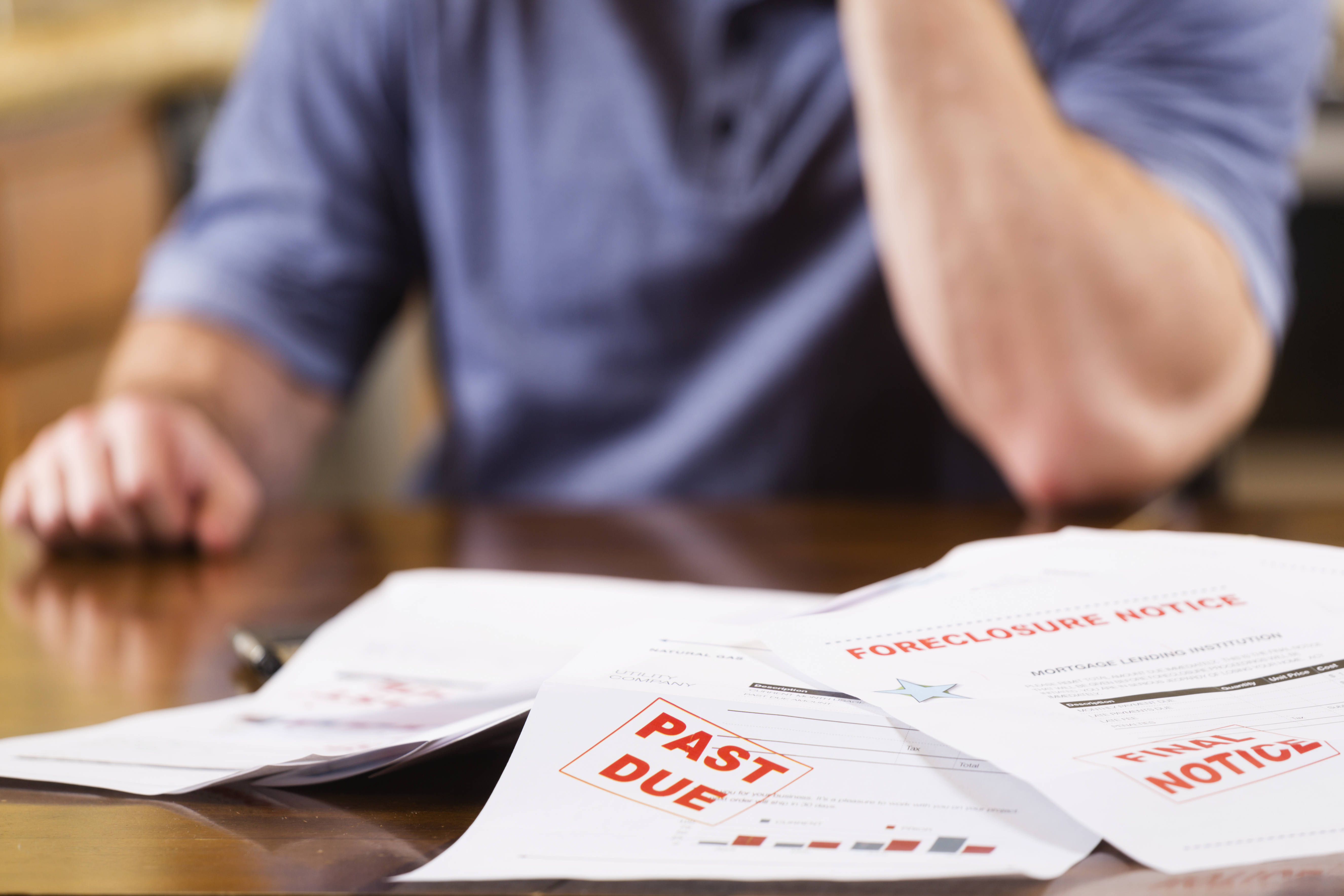 STOCK IMAGE: A man overwhelmed with past-due bills and debt. (iStock)