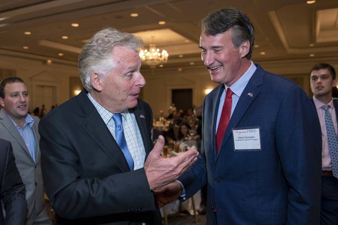 Virginia gubernatorial candidates, Democrat Terry McAuliffe, left, and Republican Glenn Youngkin, talk during the Virginia FREE's Leadership Luncheon in McLean on Wednesday. (Cliff Owen/AP)